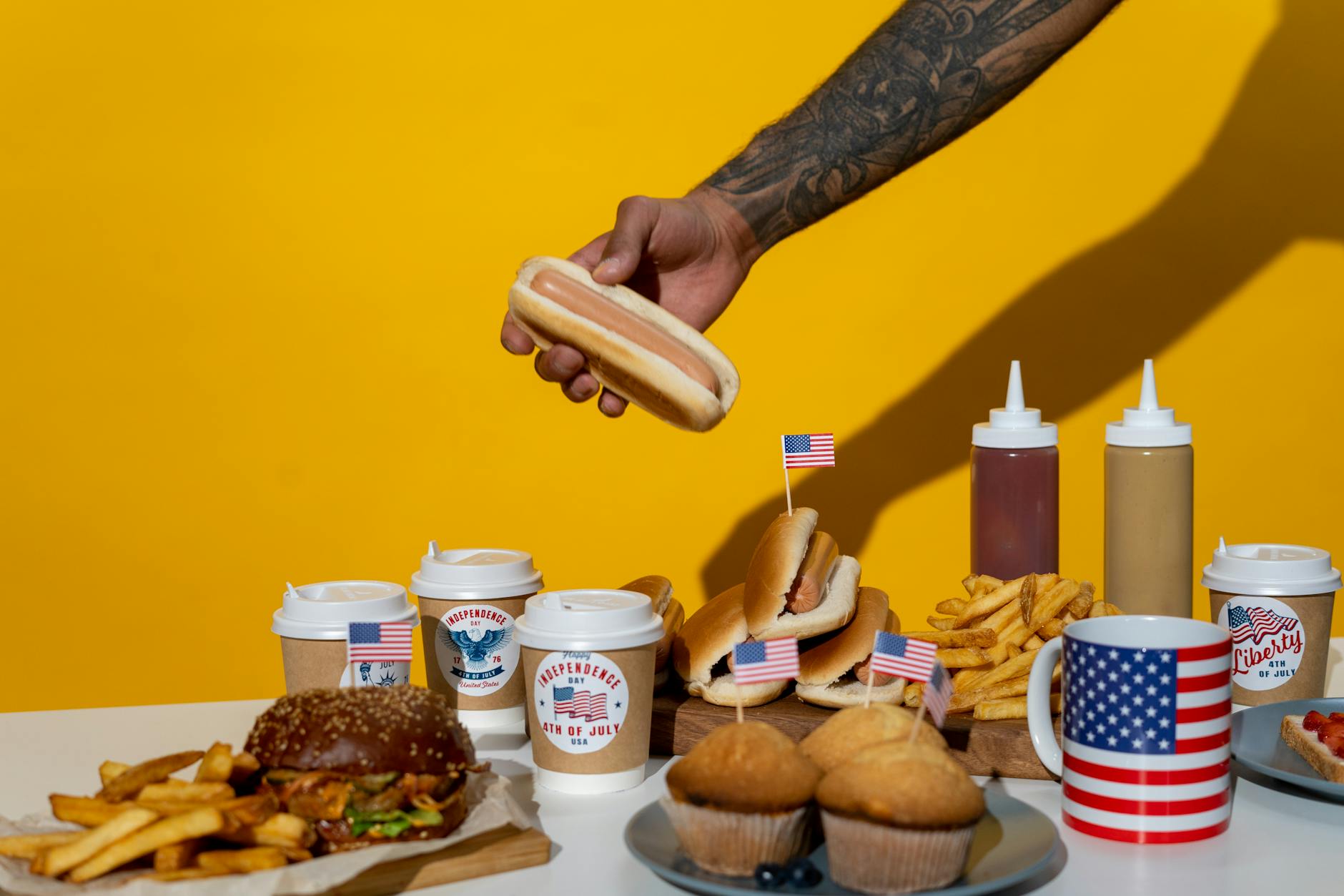 A vibrant display of American food celebrating Independence Day with hot dogs, burgers, and fries.