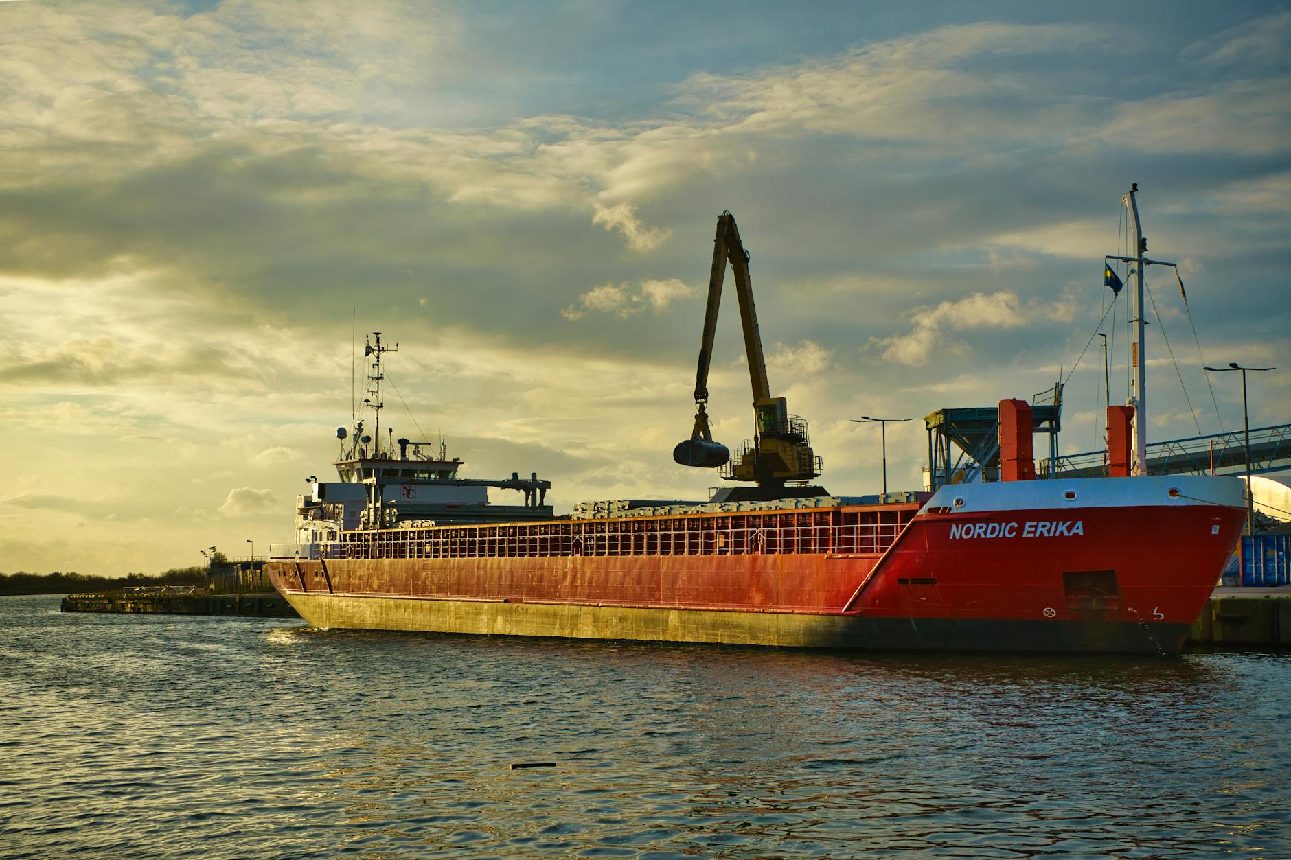 Mobilidade reduzida e mau tempo: como planear deslocações com mais segurança 8 A vibrant red cargo ship named Nordic Erika moored at a harbor during a beautiful sunset.