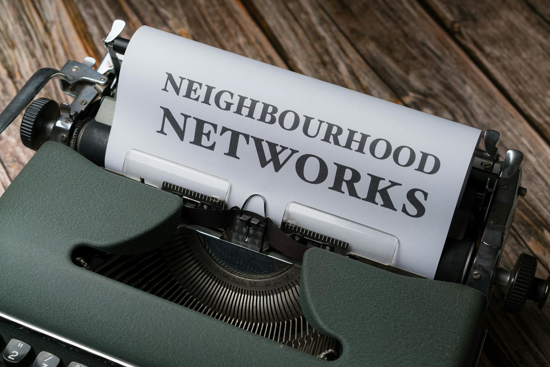 A pé em Lisboa com alerta do IPMA: rotas mais protegidas, erros comuns e o que levar contigo 7 A vintage typewriter displaying the text 'Neighbourhood Networks' on a wooden desk.
