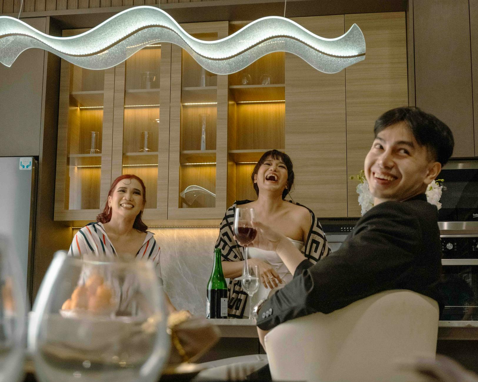 Adults enjoying a festive evening in a stylish Jakarta kitchen.