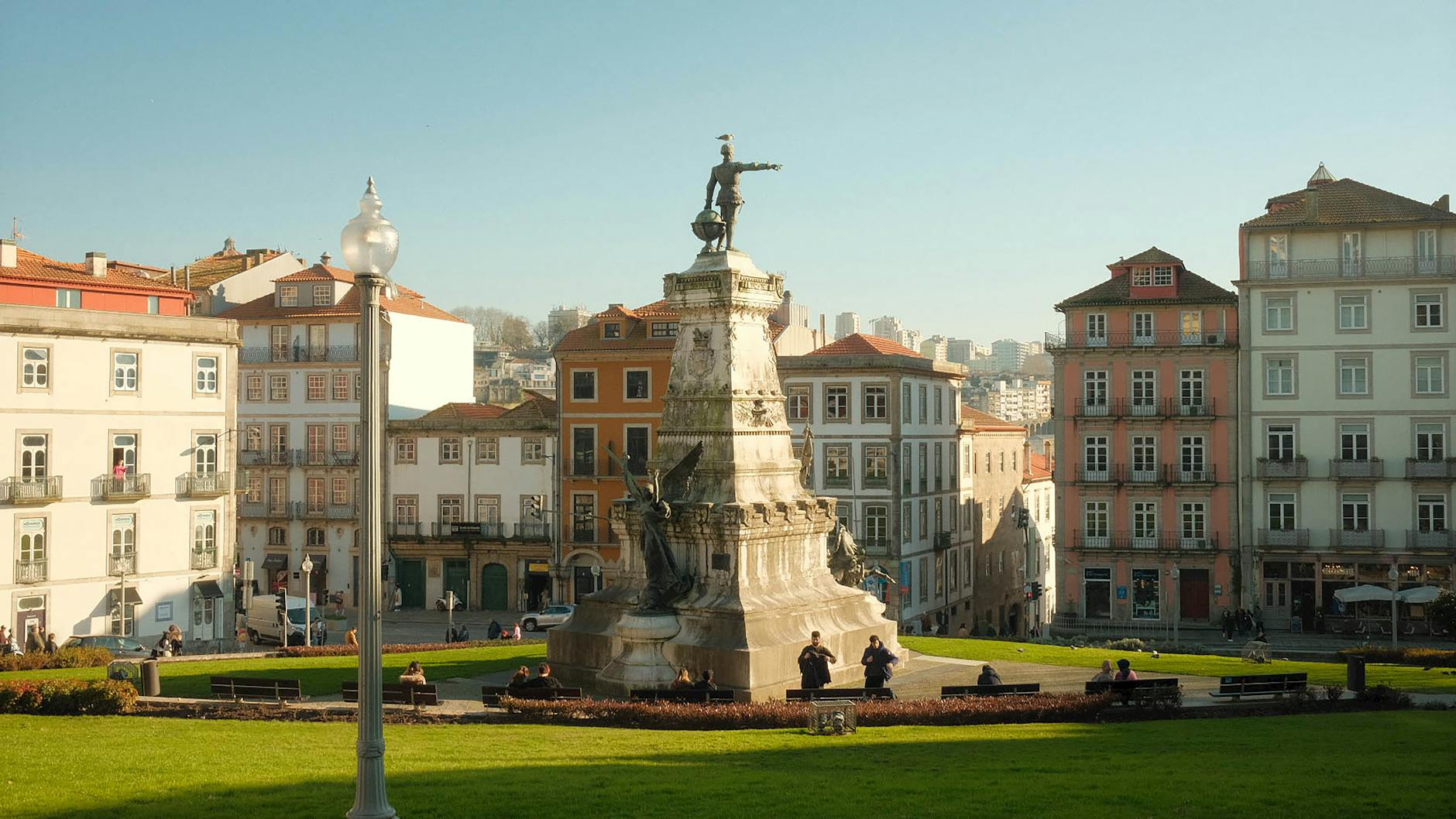 Beautiful view of a statue in Porto's historic square with traditional architecture.
