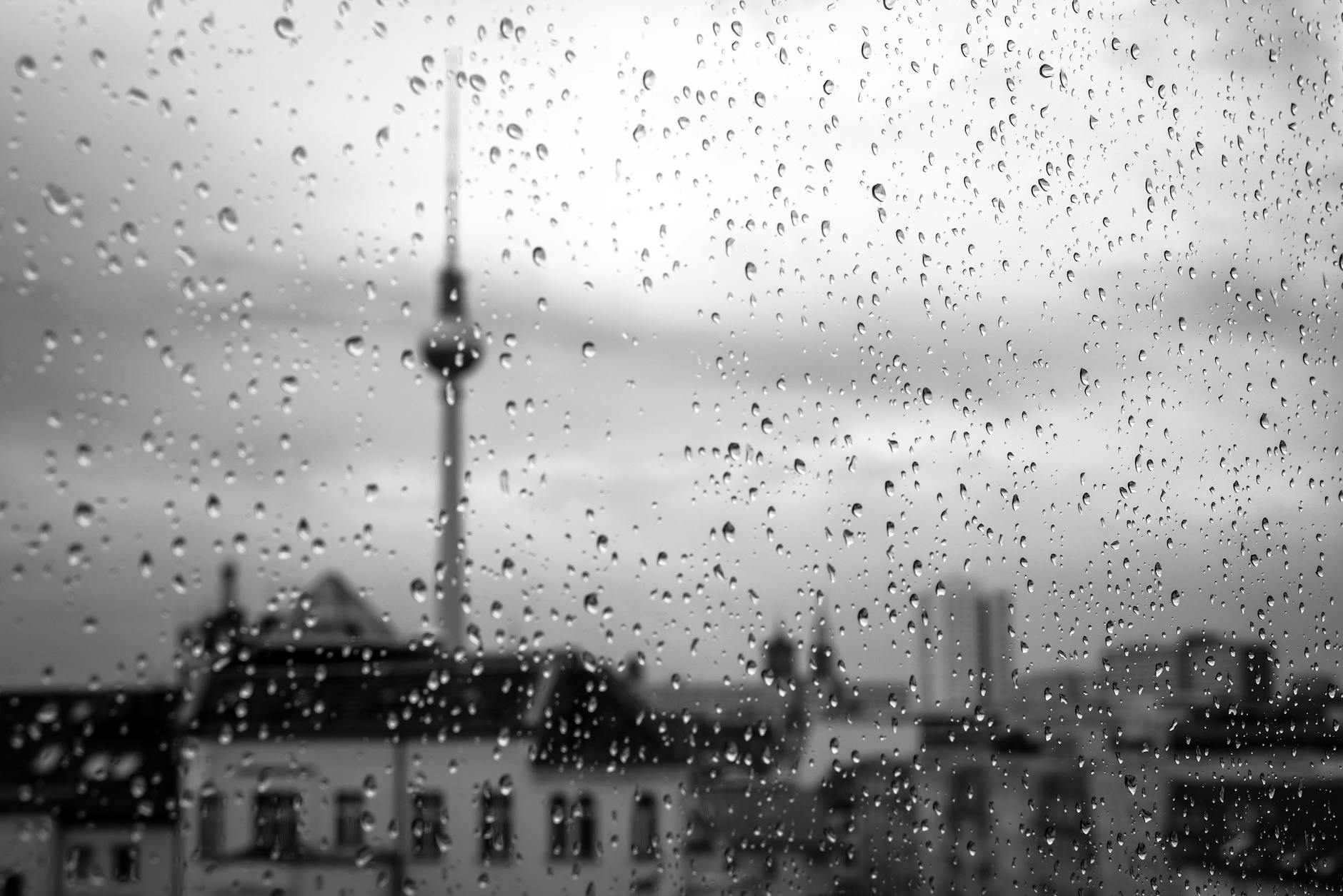 Onde Ir Em Lisboa Quando Está A Chover: Planos Zero Frustração 3 Black and white image of raindrops on a window with Berlin skyline in the background.