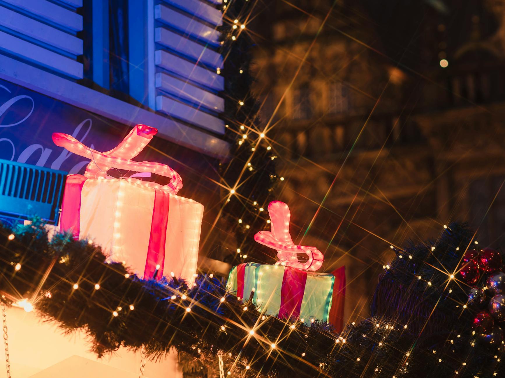 Como Aproveitar As Festas De Lisboa Sem Filas Nem Empurrões 6 Brightly lit gifts at a festive holiday market display at night.