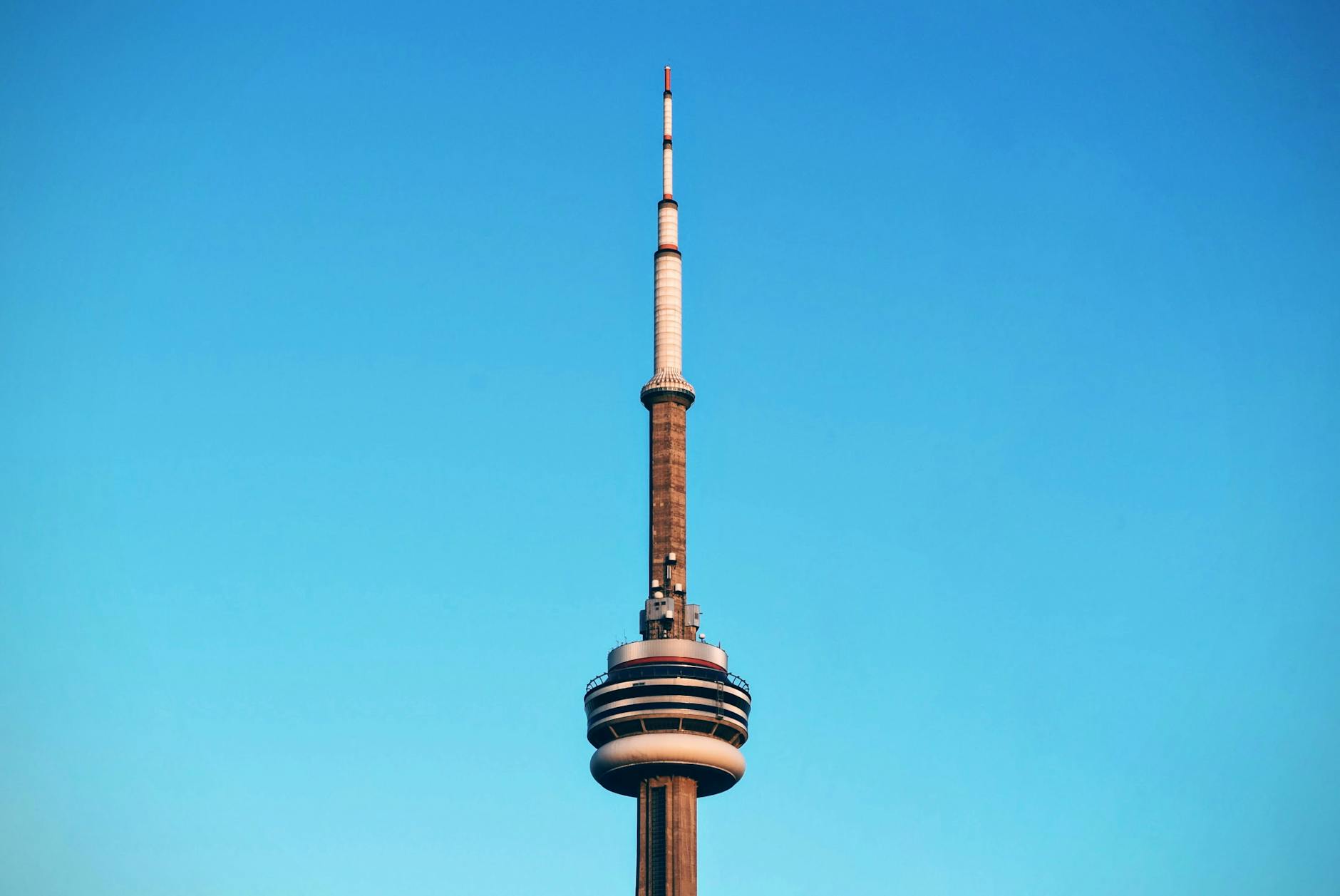 Close-up of Toronto's CN Tower reaching into a cloudless blue sky.