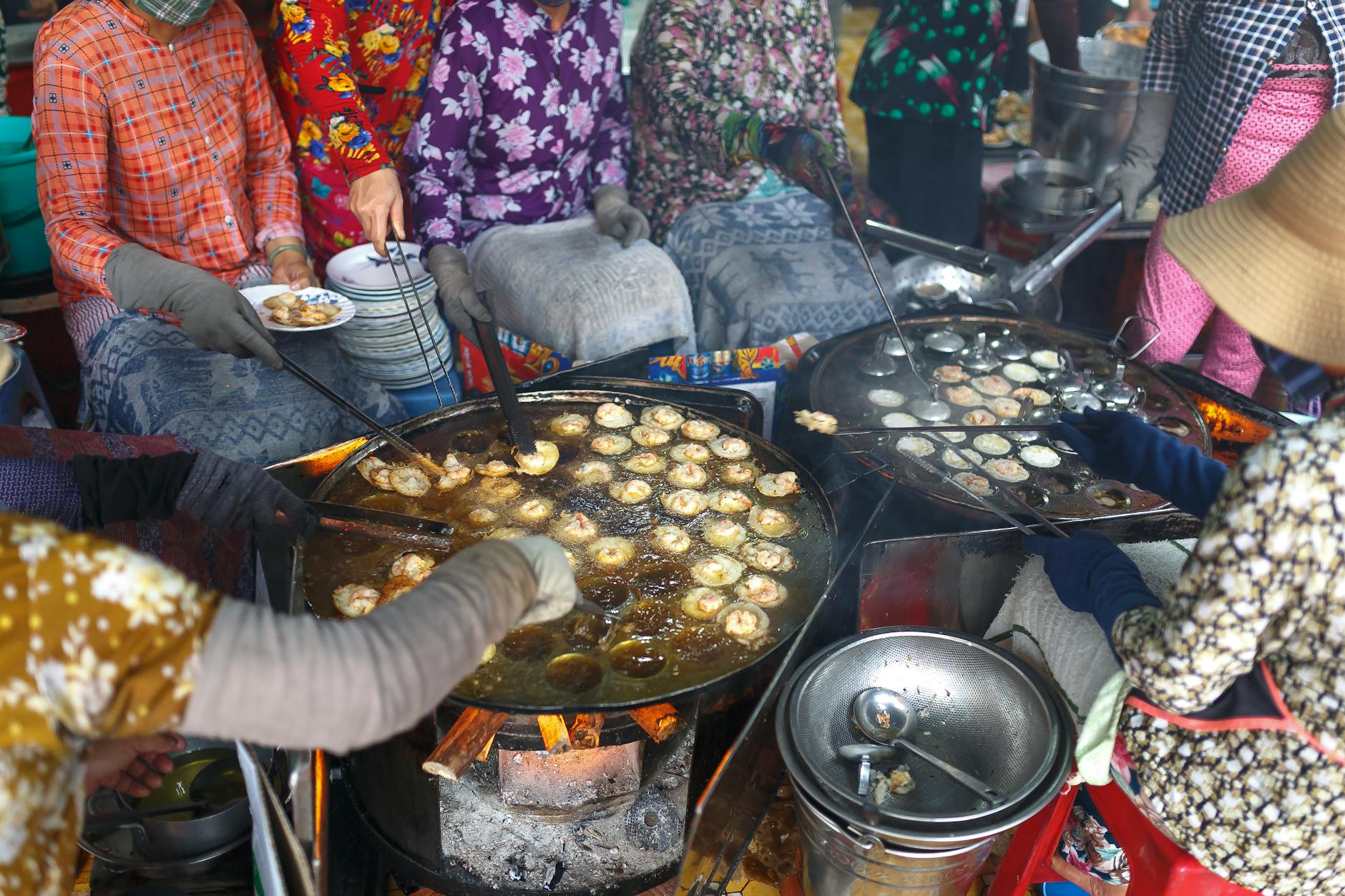 Roteiro “Só Quem Mora Sabe”: Pequenos Segredos De Lisboa 7 Colorful street food vendors frying traditional snacks at an outdoor market.