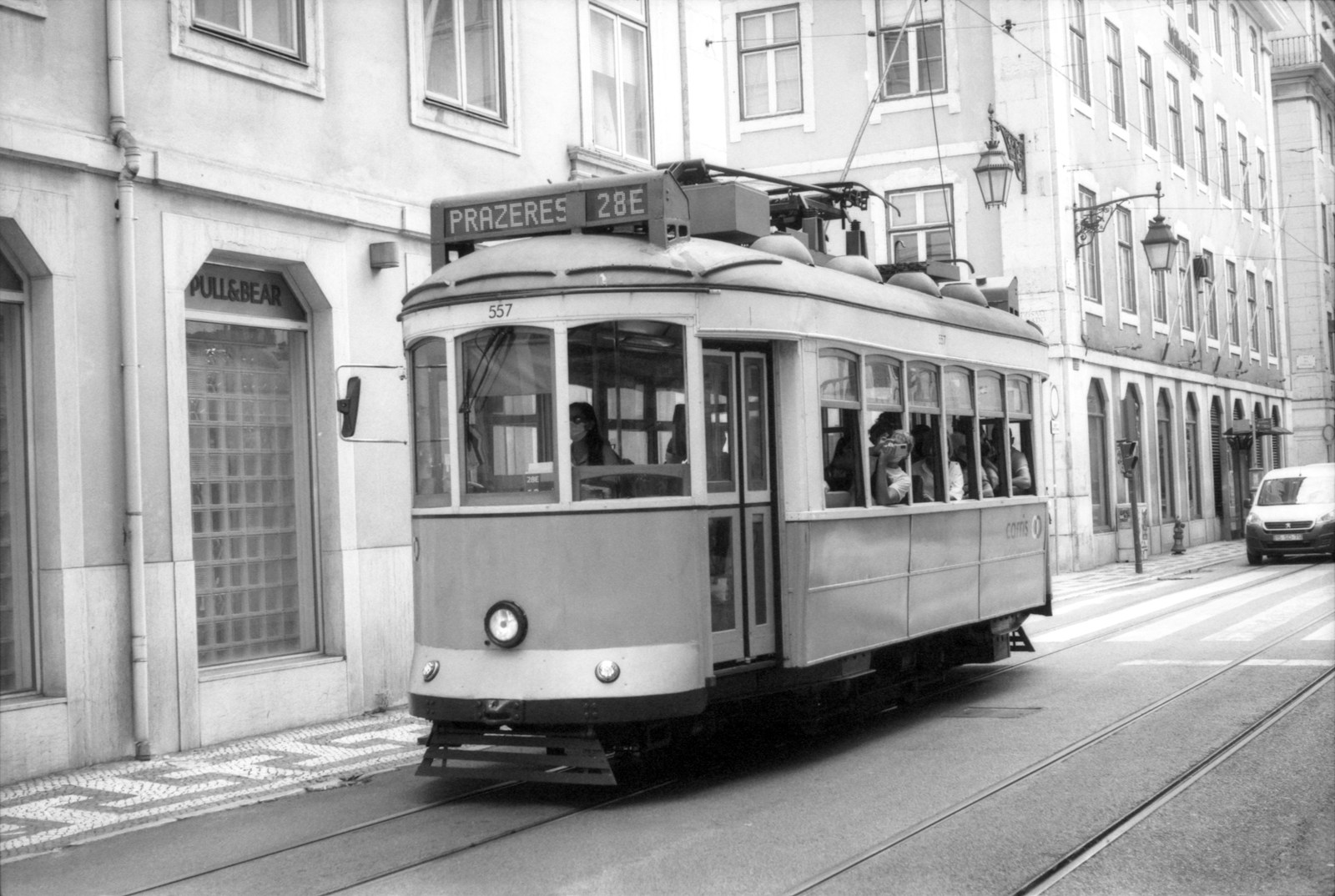 a black and white photo of a trolley on a street