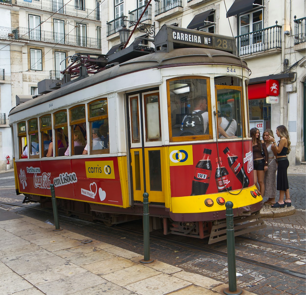 A vintage tram travels down a city street.