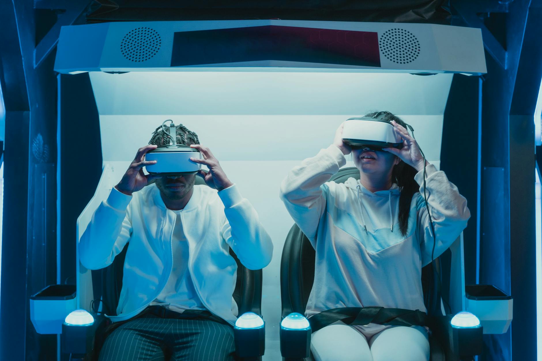 ModaLisboa: Como Ver O Melhor Sem Ser “Do Meio” 6 Two adults engaged in a virtual reality experience using VR headsets in a futuristic setting.