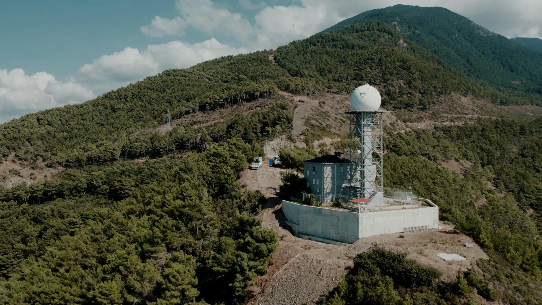 Weather station nestled in the lush mountains of Hatay, Türkiye, under a clear sky.