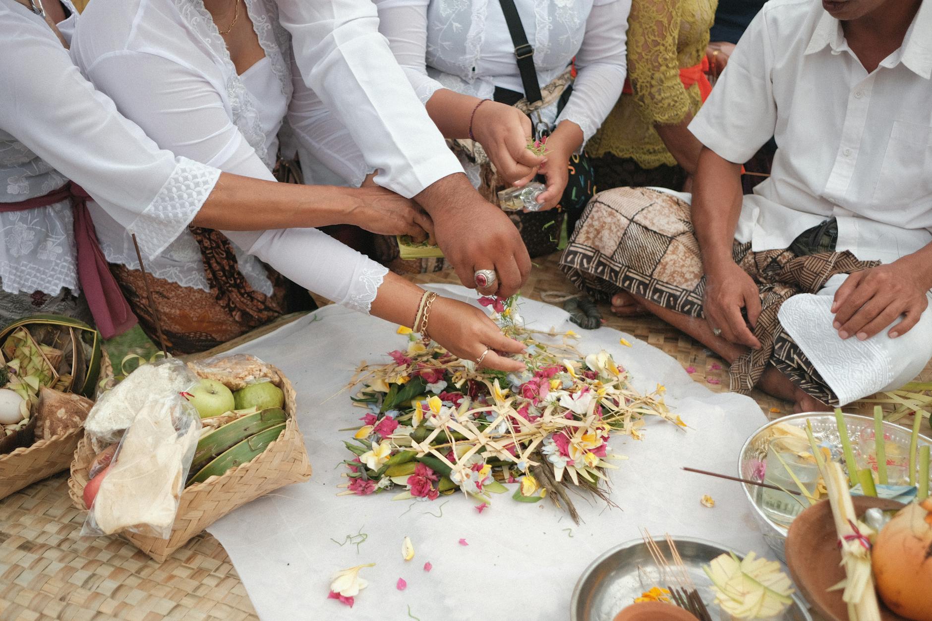 Como Planear O Fim De Semana Em Lisboa Em 10 Minutos 5 A close-up of hands arranging Balinese flower offerings in a cultural ceremony, showcasing tradition.