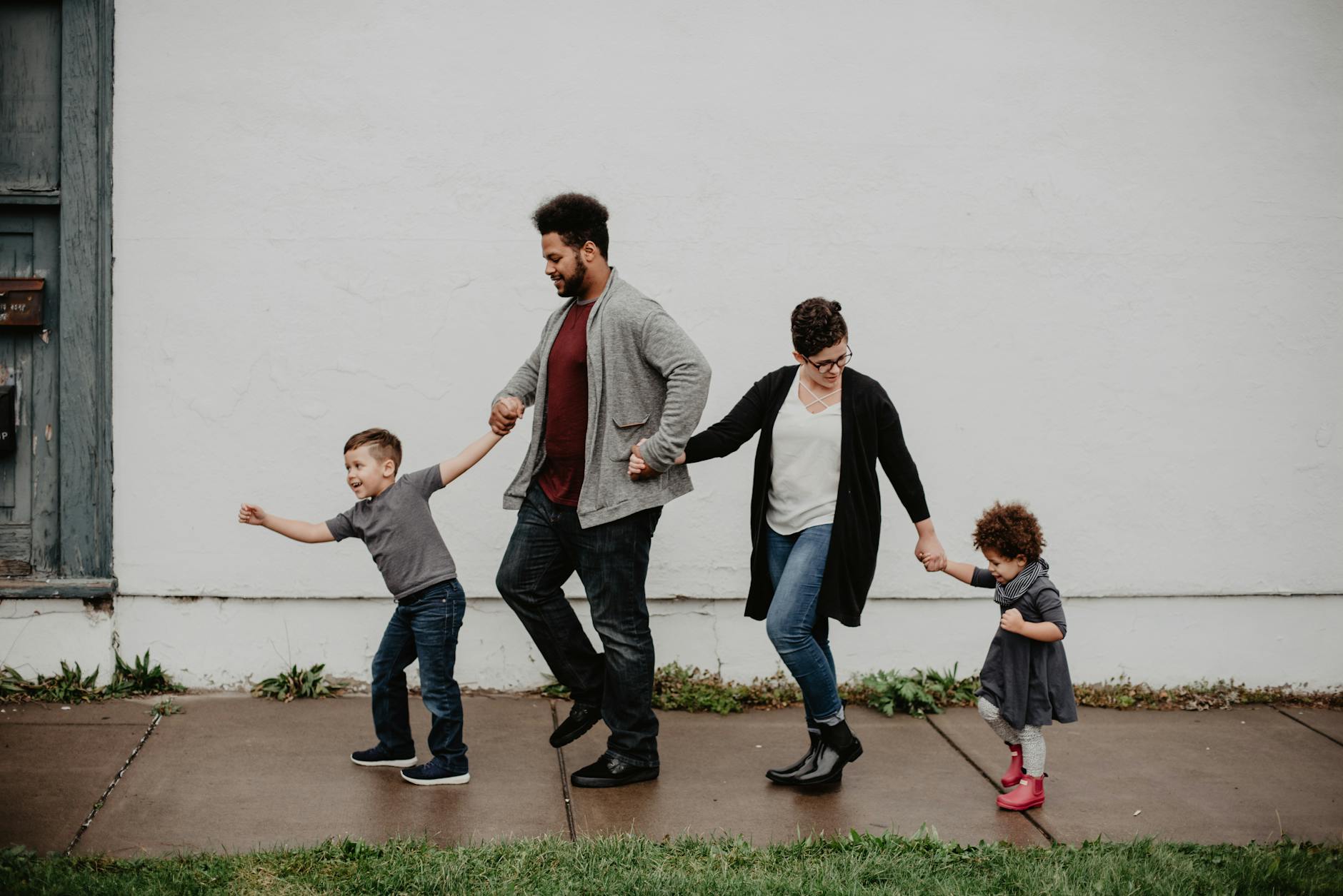 O Que Há De Novo Em Parque das Nações: Passeios, Comida E Planos Com Vista 6 A joyful family walking together outdoors, holding hands in a playful and happy moment.