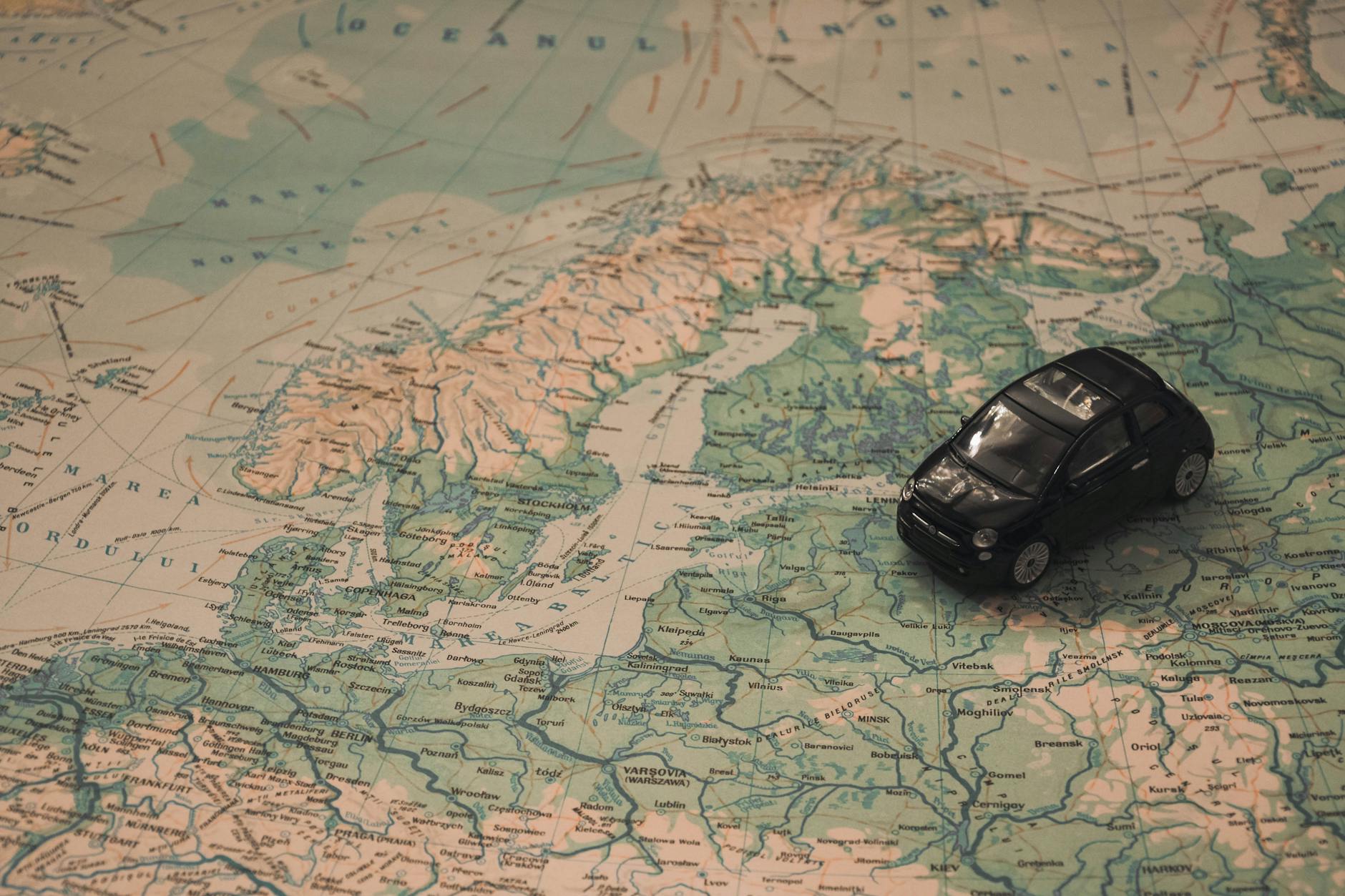 Barcos No Tejo: Como Aproveitar A Transtejo/Soflusa Para Ir E Voltar Com Vista 6 A miniature black car on a detailed map of Scandinavia, symbolizing travel adventures.