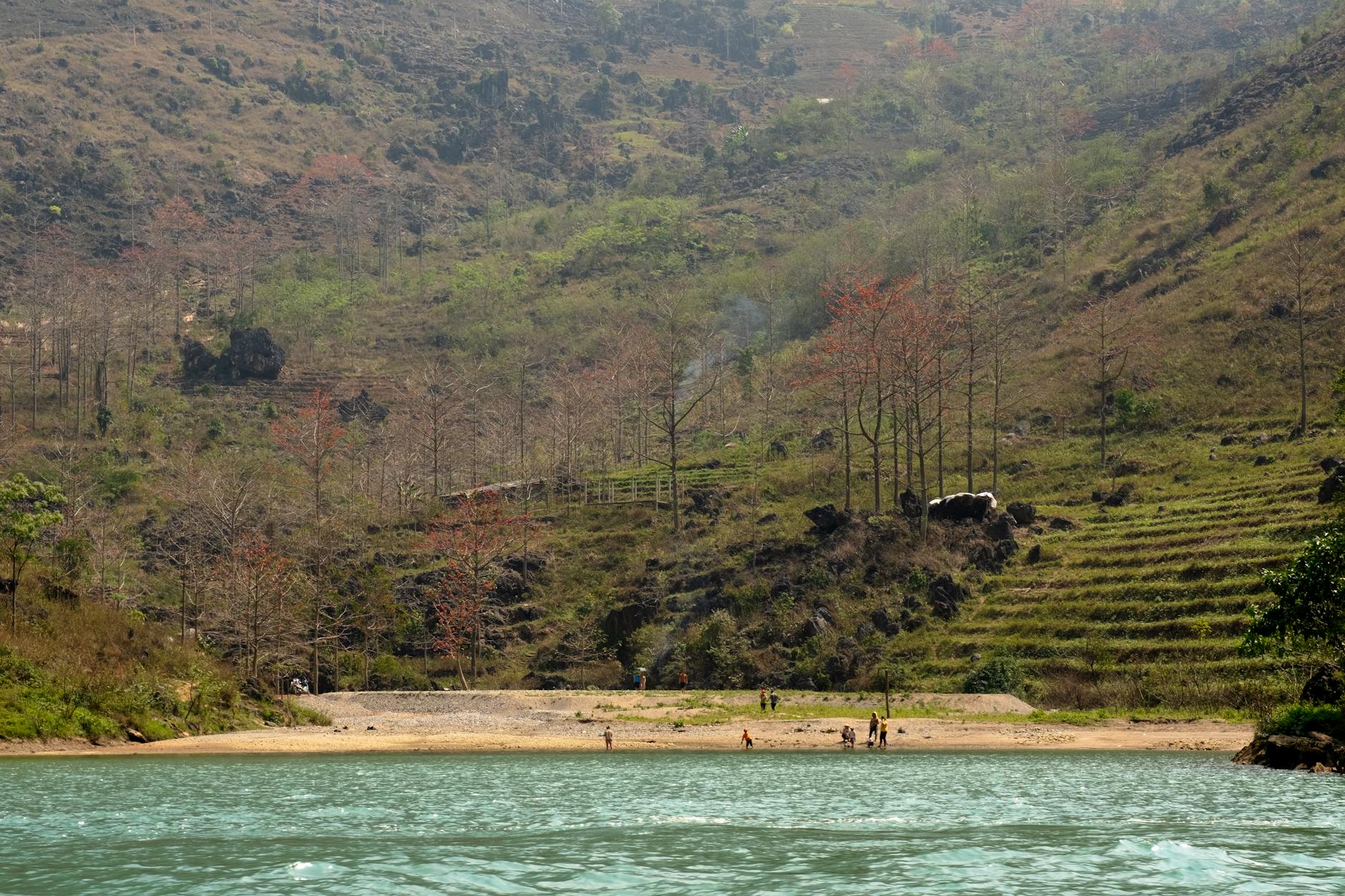 A picturesque riverside scene featuring tourists enjoying the serene landscape in Vietnam.