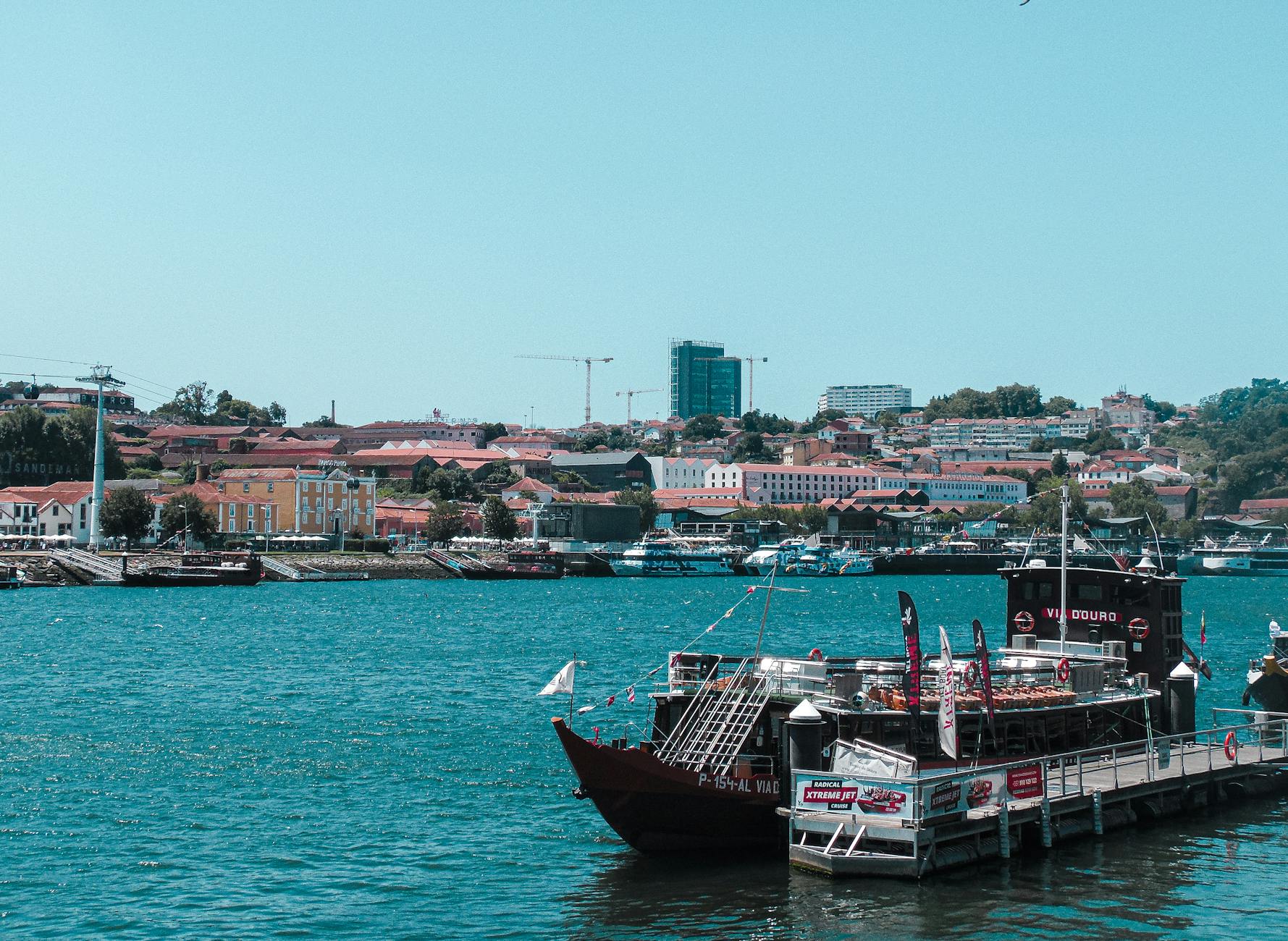 A picturesque view of the Douro River, traditional boats, and Porto's iconic Ribeira District.
