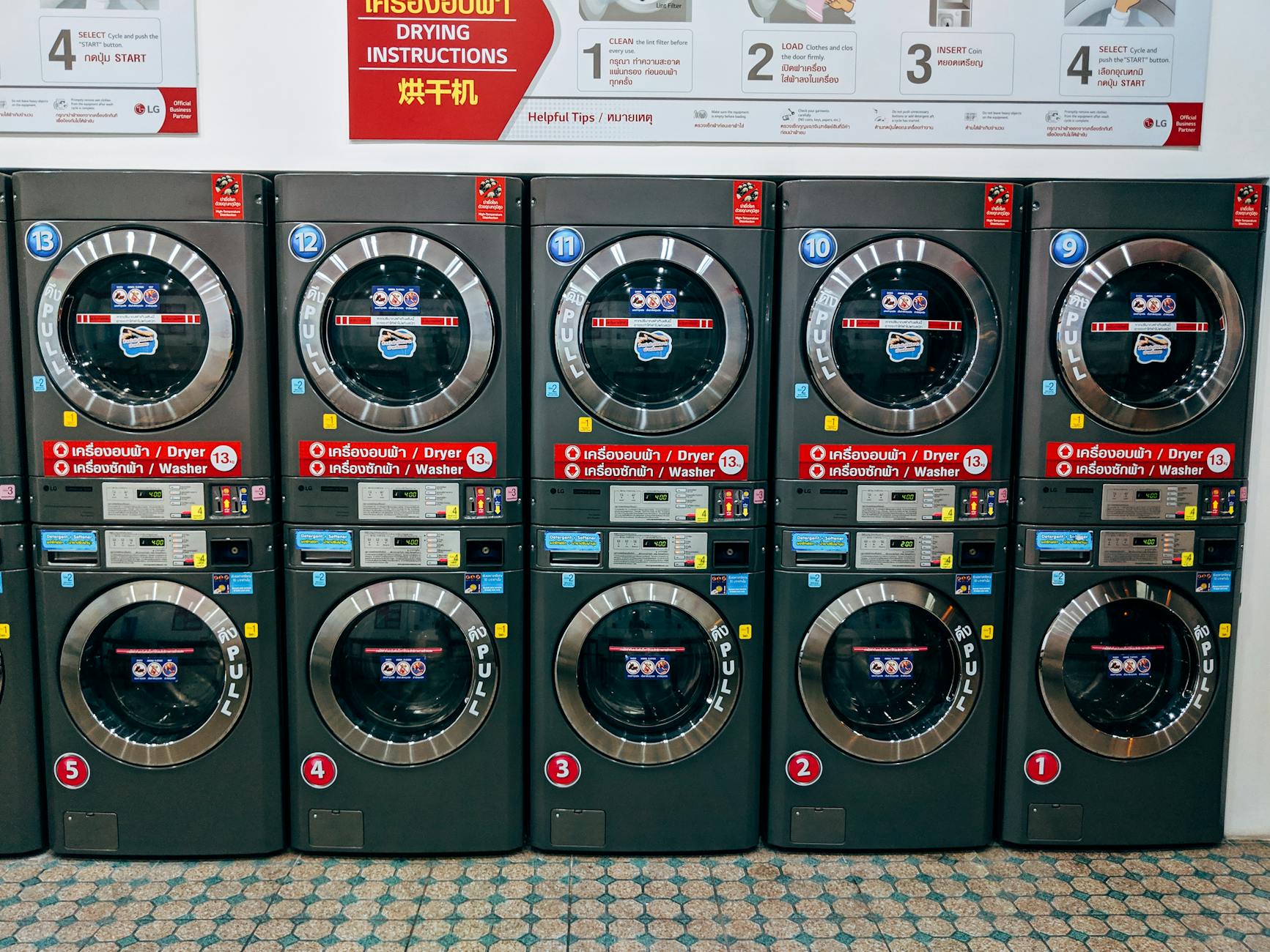 A row of modern washing machines in a public laundromat in Chiang Mai, Thailand.