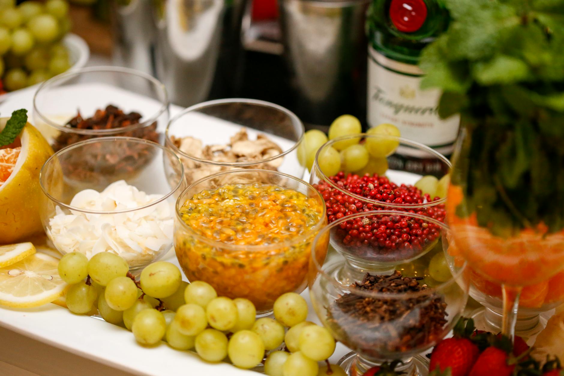 A spread of fresh fruits, spices, and herbs arranged beautifully for cooking or cocktails.