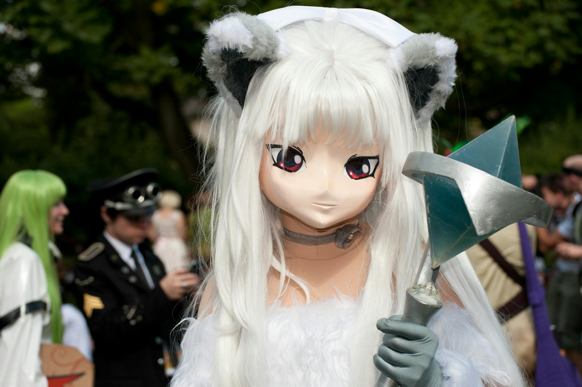 A striking cosplay character with unique costume at an outdoor convention setting.