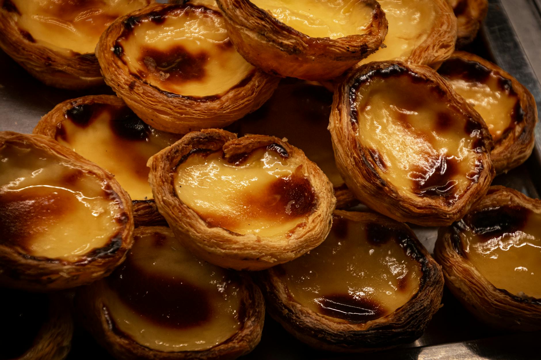 Como Planear O Fim De Semana Em Lisboa Em 10 Minutos 4 A tempting display of traditional Portuguese Pastel de Nata pastries, glistening with caramelized tops.