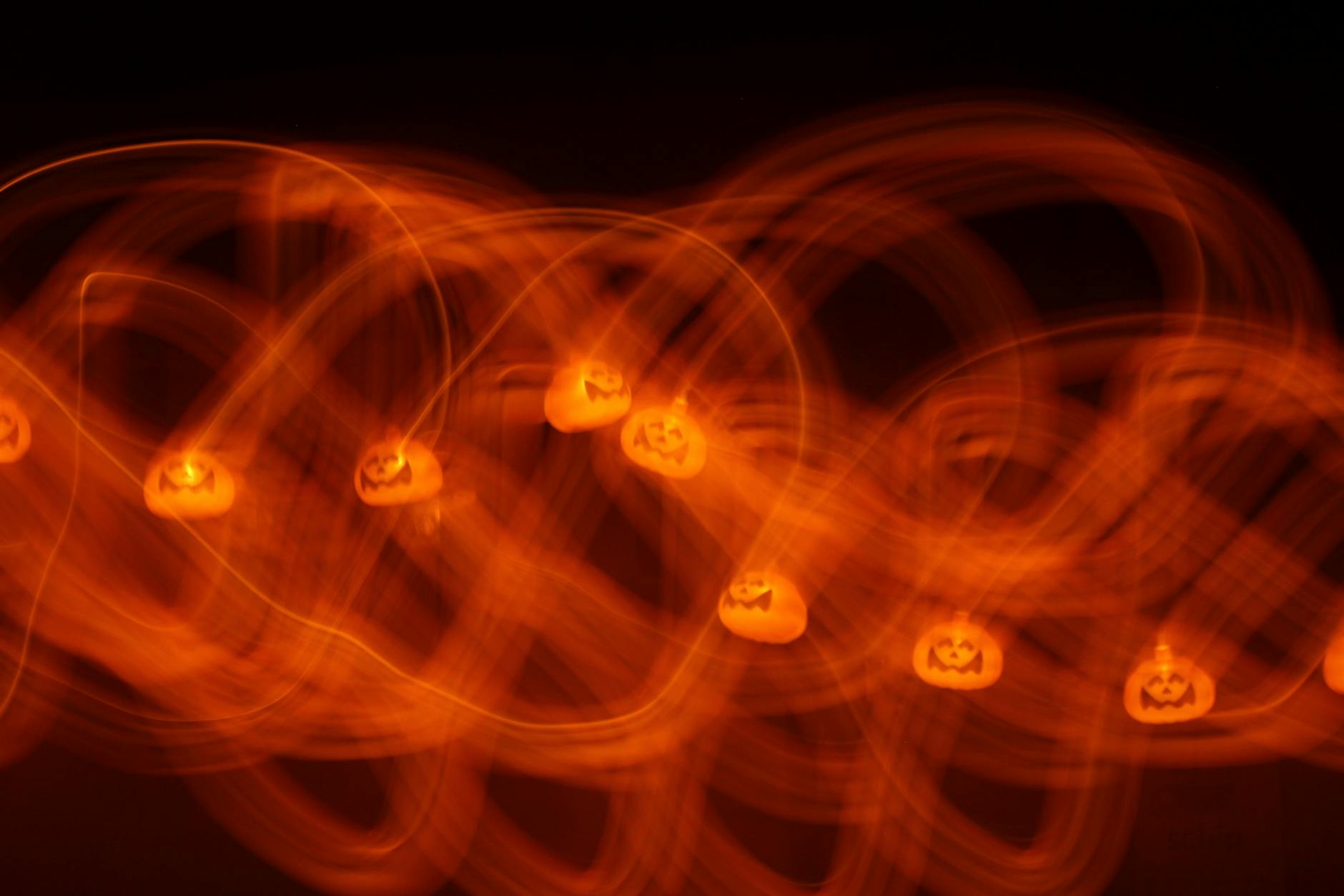 Abstract view of orange pumpkin lights with motion blur creating festive Halloween atmosphere.