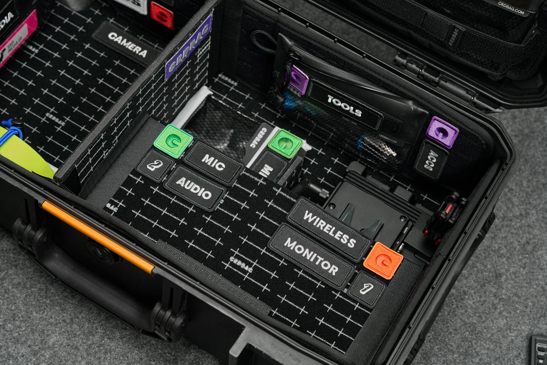 An organized hardcase displaying labeled compartments for camera, audio, and wireless equipment.