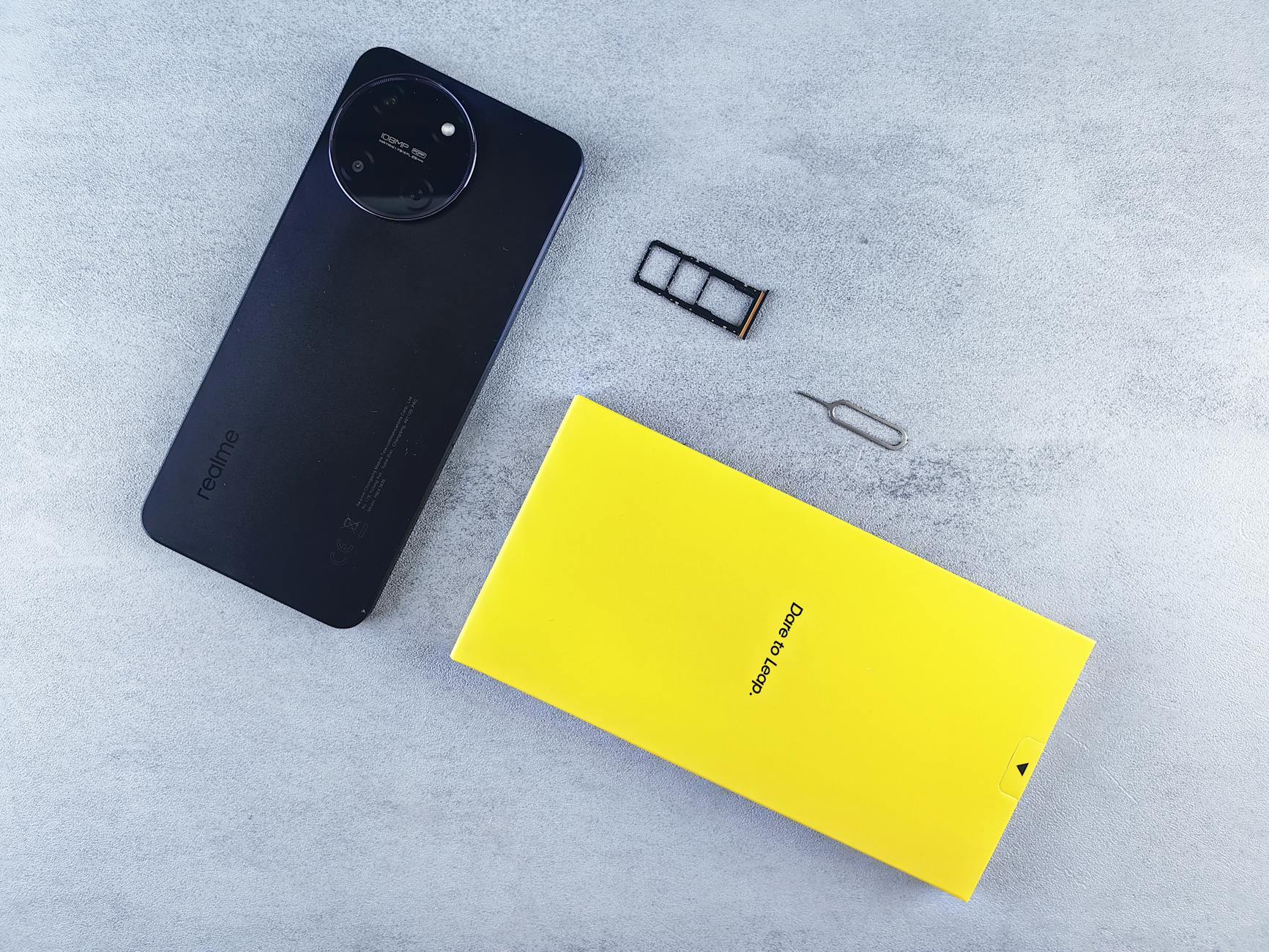 LUMINA: “vale a pena em noite de chuva?” sim — e como aproveitar 6 Black smartphone with yellow box, dual SIM tray, and SIM ejector tool on grey surface.