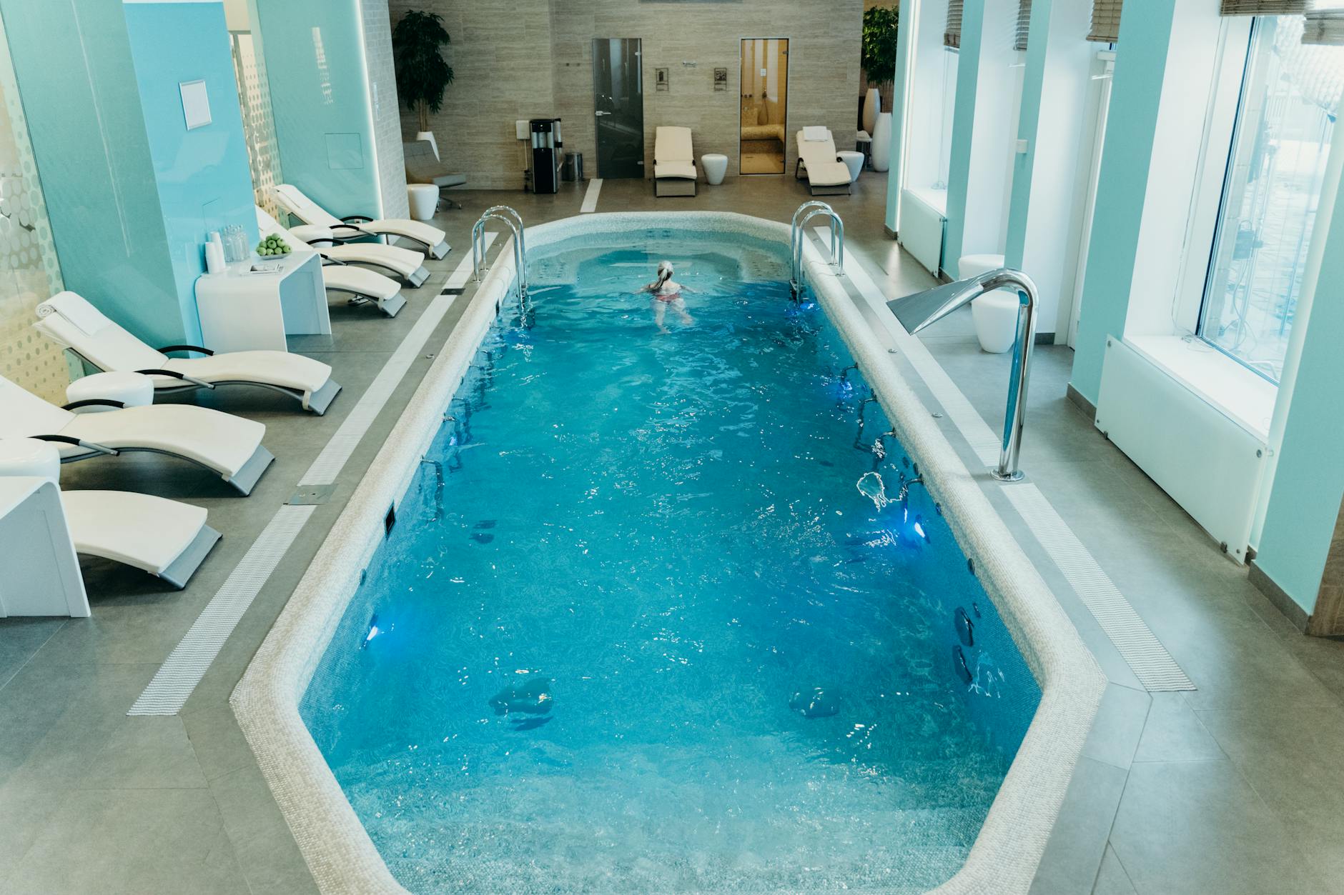 Spas E Banhos Em Lisboa: Onde Relaxar Sem Pagar Luxo 5 Bright indoor spa pool with lounge chairs and calm atmosphere, ideal for relaxation.
