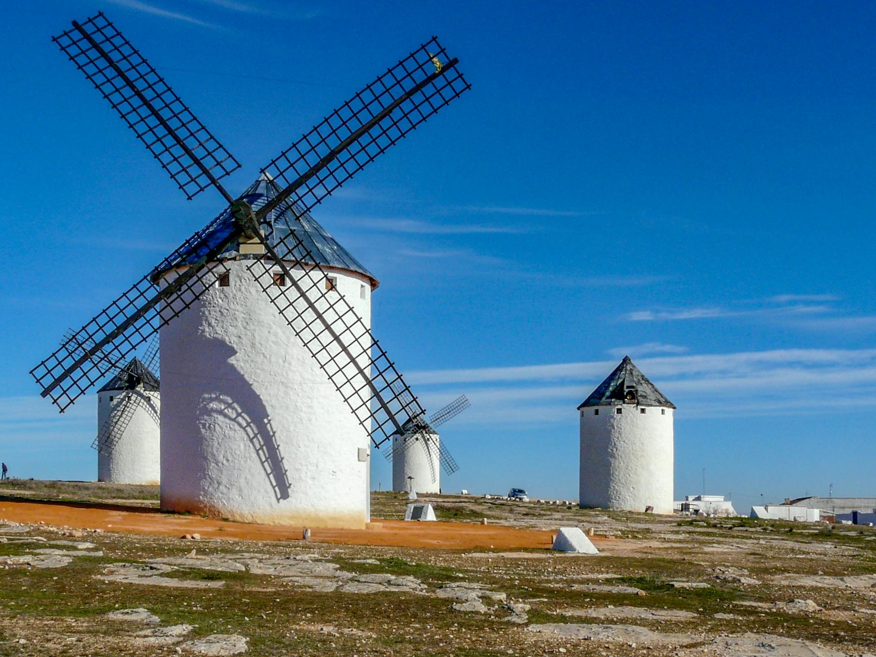 Captivating view of historic windmills under a vivid blue sky in Campo de Criptana, Spain.