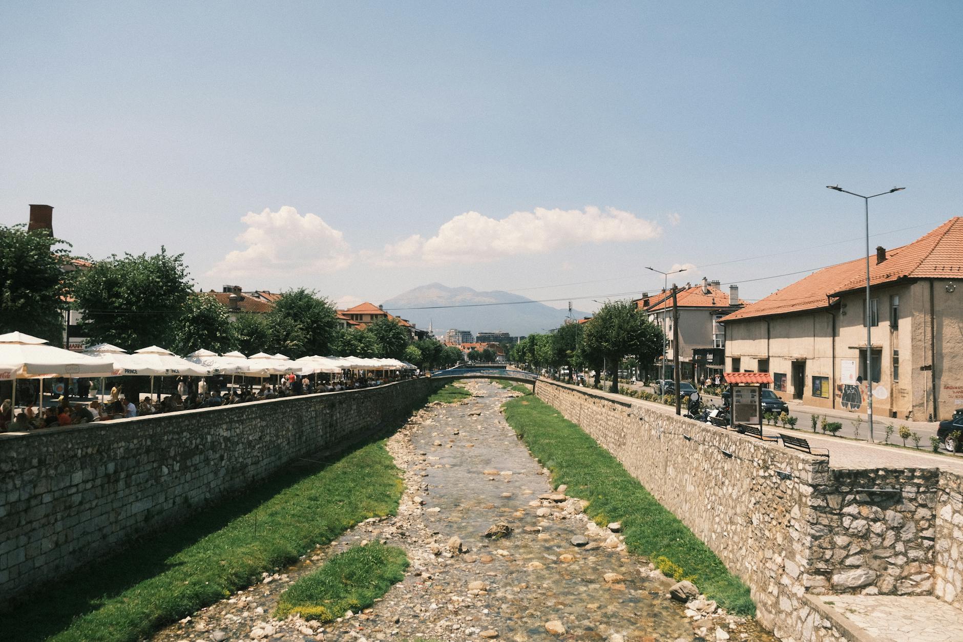 BaixAnima: os horários que costumam ter menos confusão (e mais magia) 6 Captivating view of Prizren river with cityscape and outdoor cafes in summer