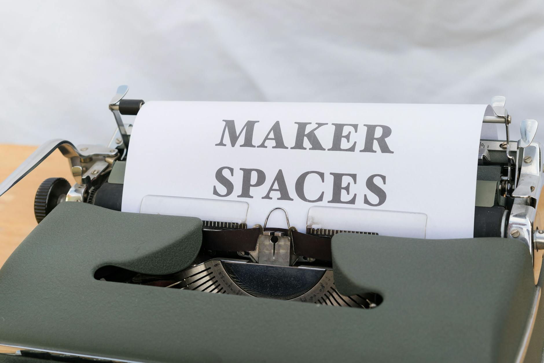 Como sair de eventos grátis e voltar para casa sem stress (dicas reais) 3 Close-up of a vintage typewriter with a paper reading 'Maker Spaces,' ideal for educational and creative content.