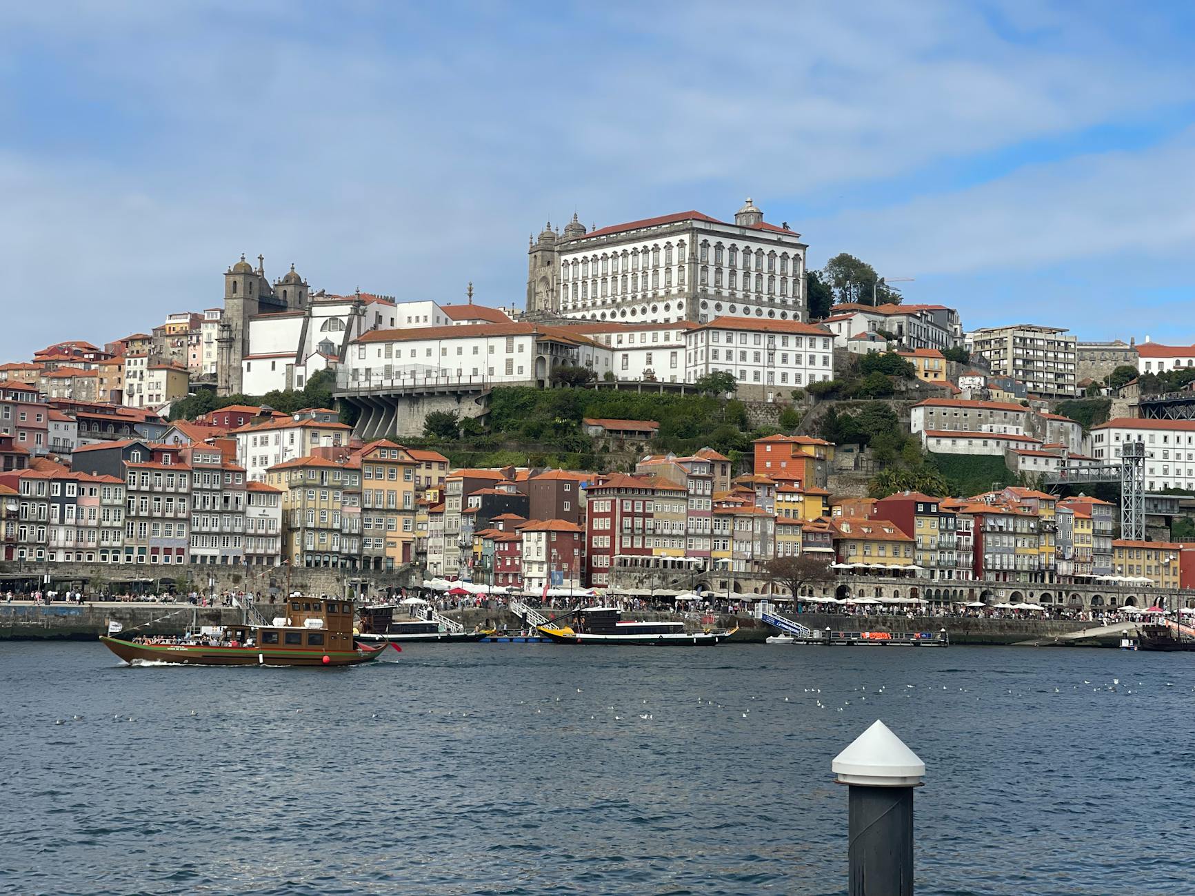 Colorful buildings of Ribeira district along Douro River in Porto, Portugal, under a bright blue sky.