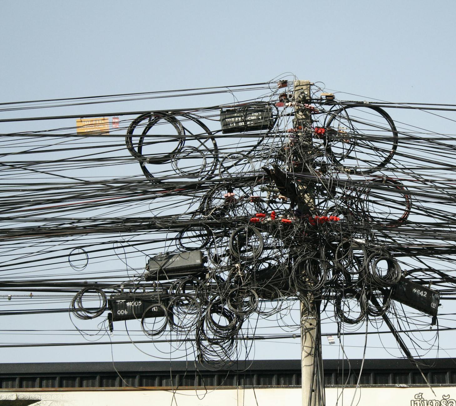 Complex network of tangled power lines and cables in Chiang Mai, Thailand.