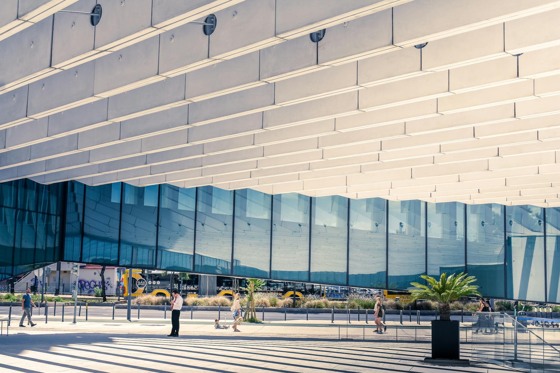 Contemporary urban architecture in Lisboa, showcasing reflections and human interaction.
