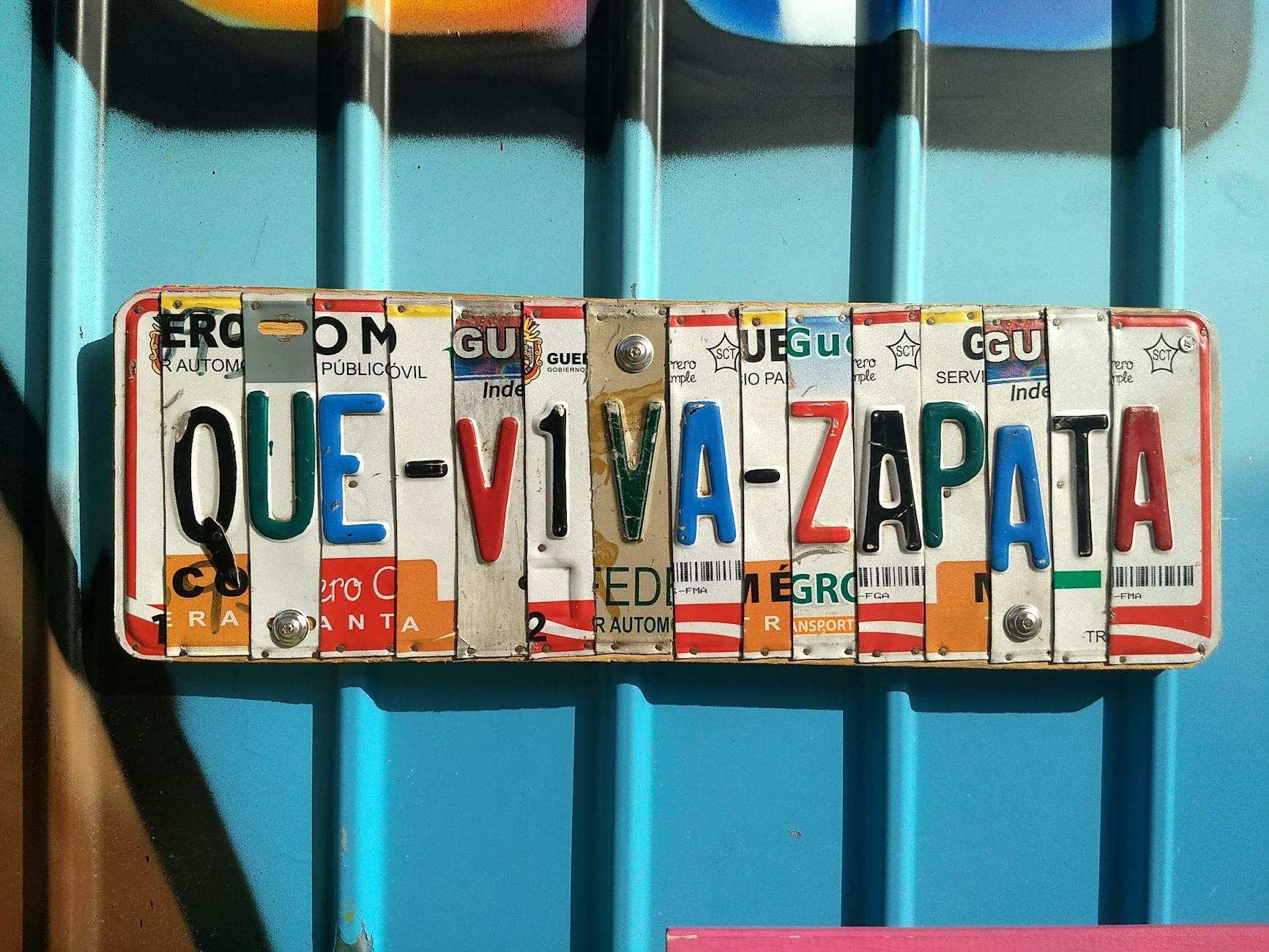 Street art: o que levar para um passeio longo sem derreter ao sol 8 Creative license plate design featuring vibrant colors and typography saying 'Que Viva Zapata'.