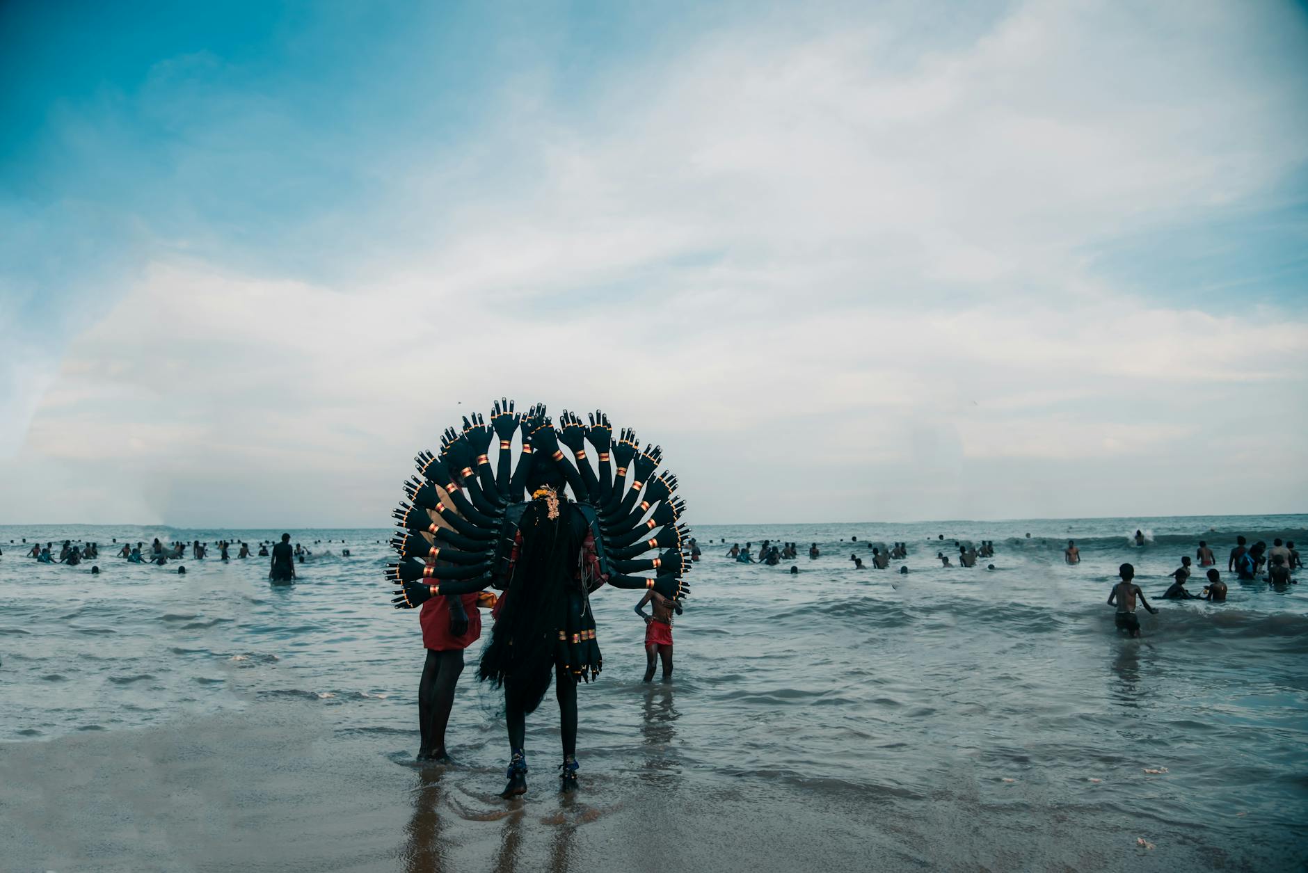 Crowd enjoying the Kulasai Dasara festival with traditional attire on a beach.