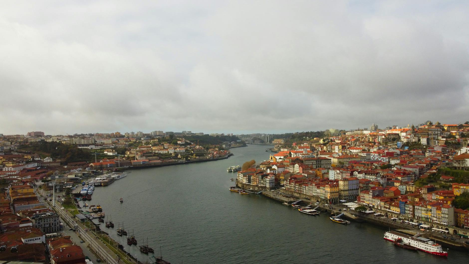 Drone shot of Porto's urban landscape with the Douro River, capturing the historic architecture and scenic skyline.