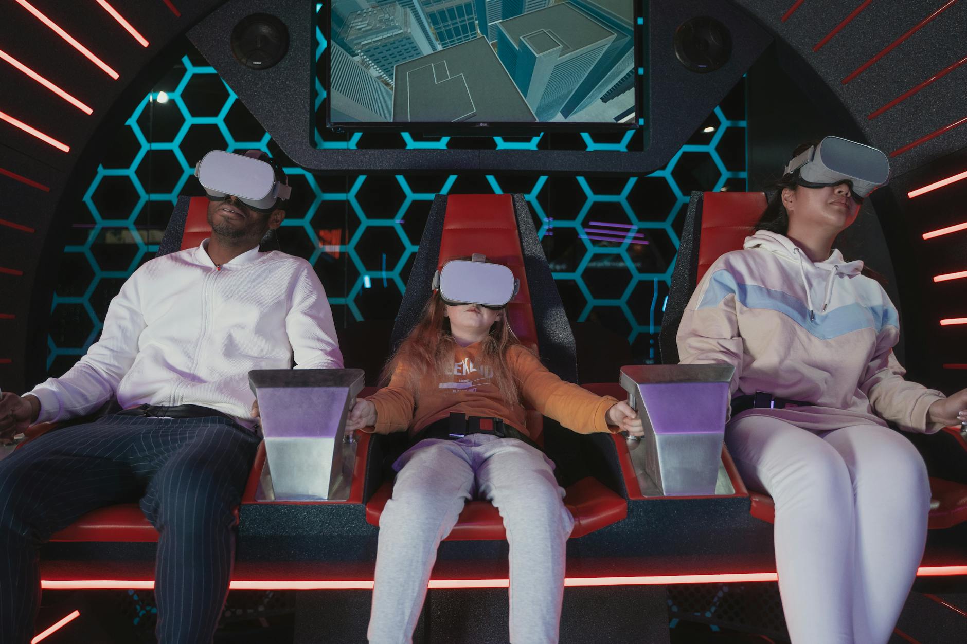 Family enjoying a virtual reality simulator ride indoors, showcasing VR technology and entertainment.