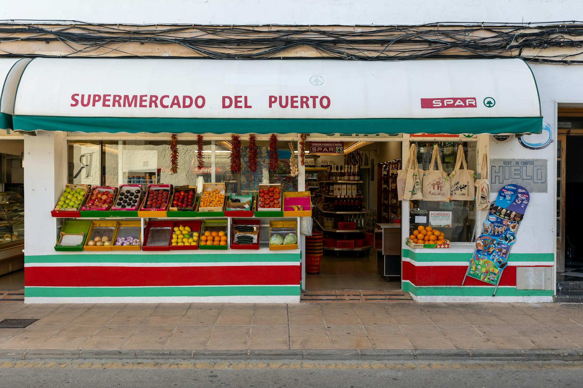 Front view of a vibrant fruit stand at Supermercado Del Puerto in Palma, Spain.