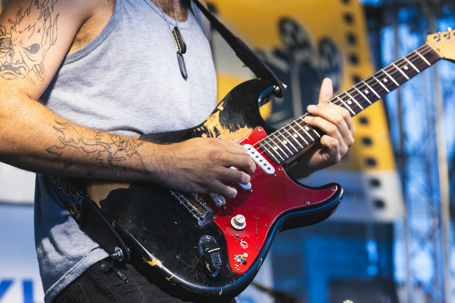 Guitarist with tattoos performing outdoors at Kutná Hora festival.