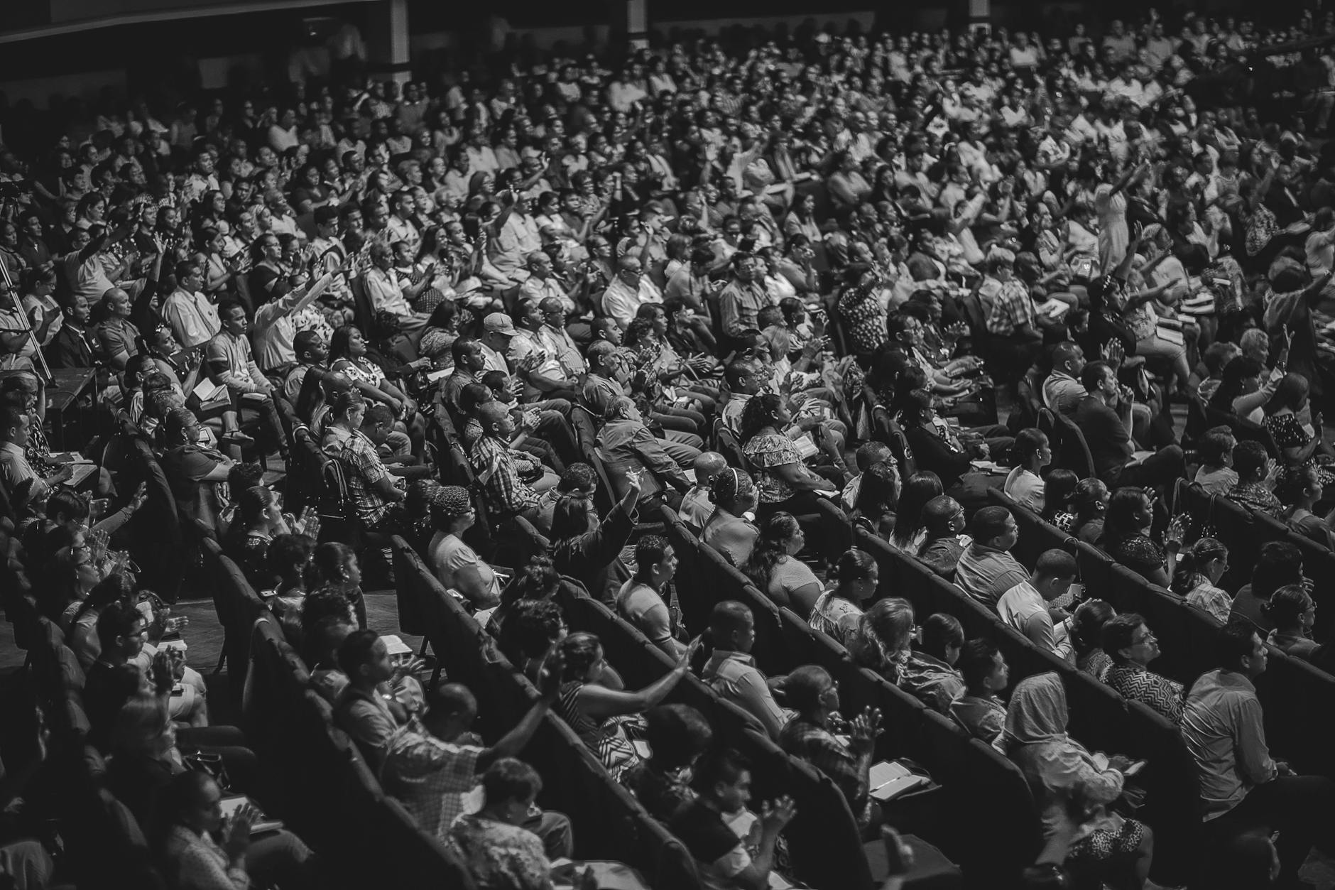 High angle view of a diverse audience in a theater setting, captured in monochrome.