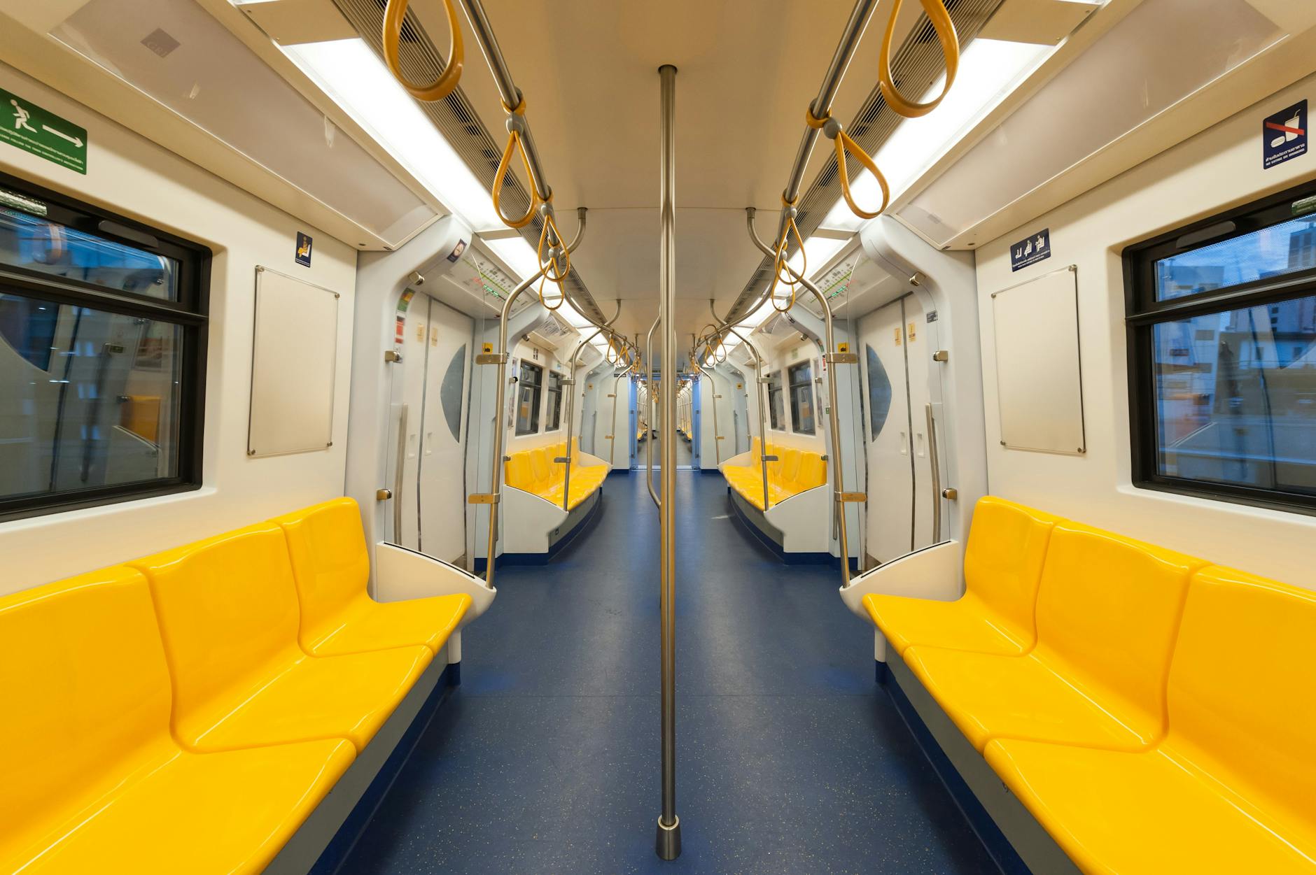 Interior of a modern subway car with bright yellow seats and clean design, emphasizing public transportation.