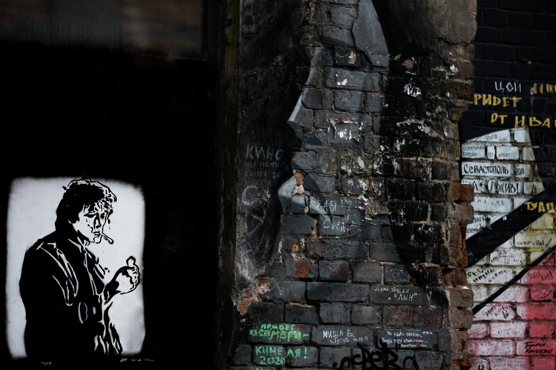 Intricate street art with murals and graffiti on a brick wall, showcasing urban creativity.
