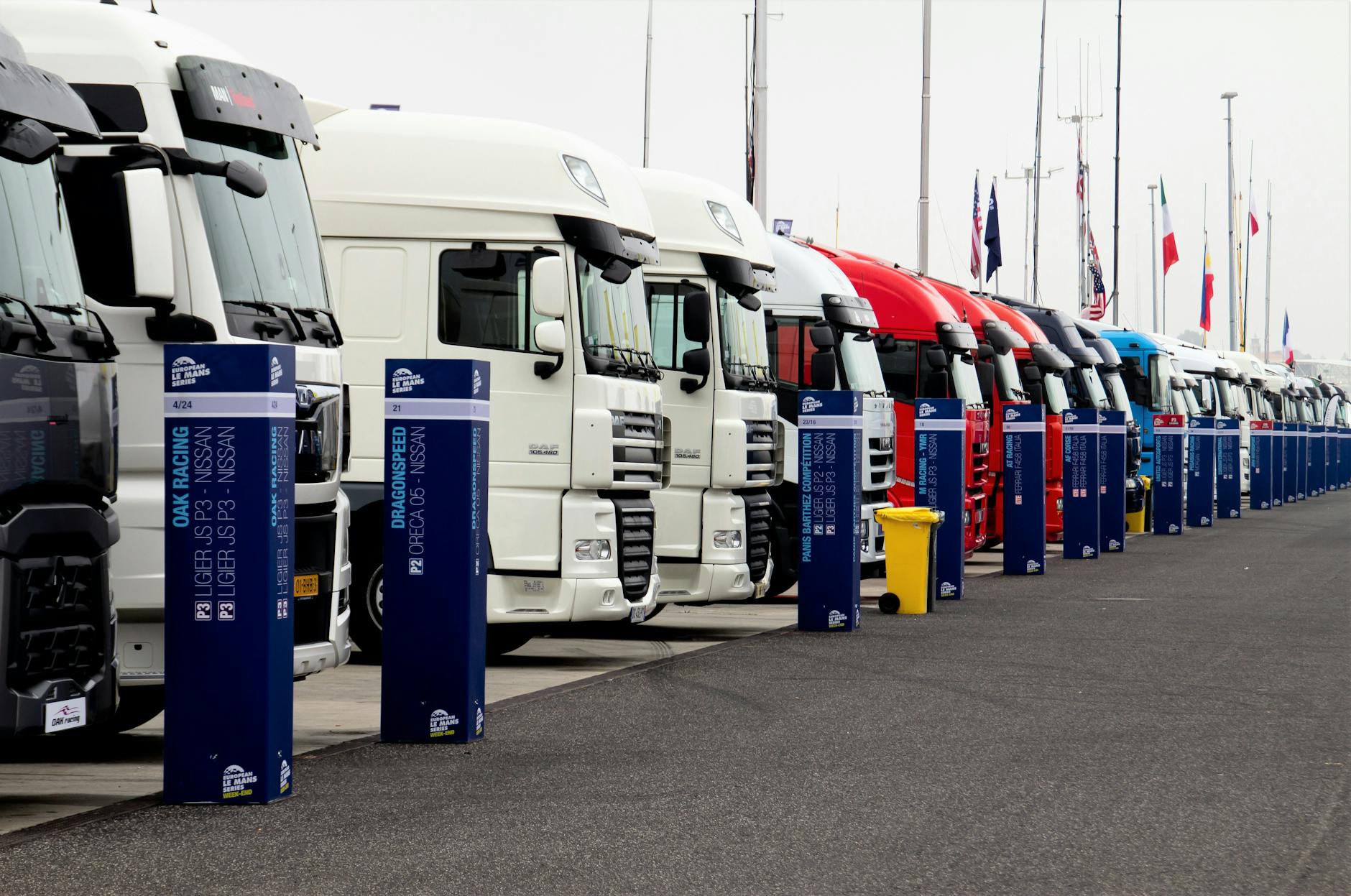Line of racing trucks with bollards at event in Estoril, Portugal.