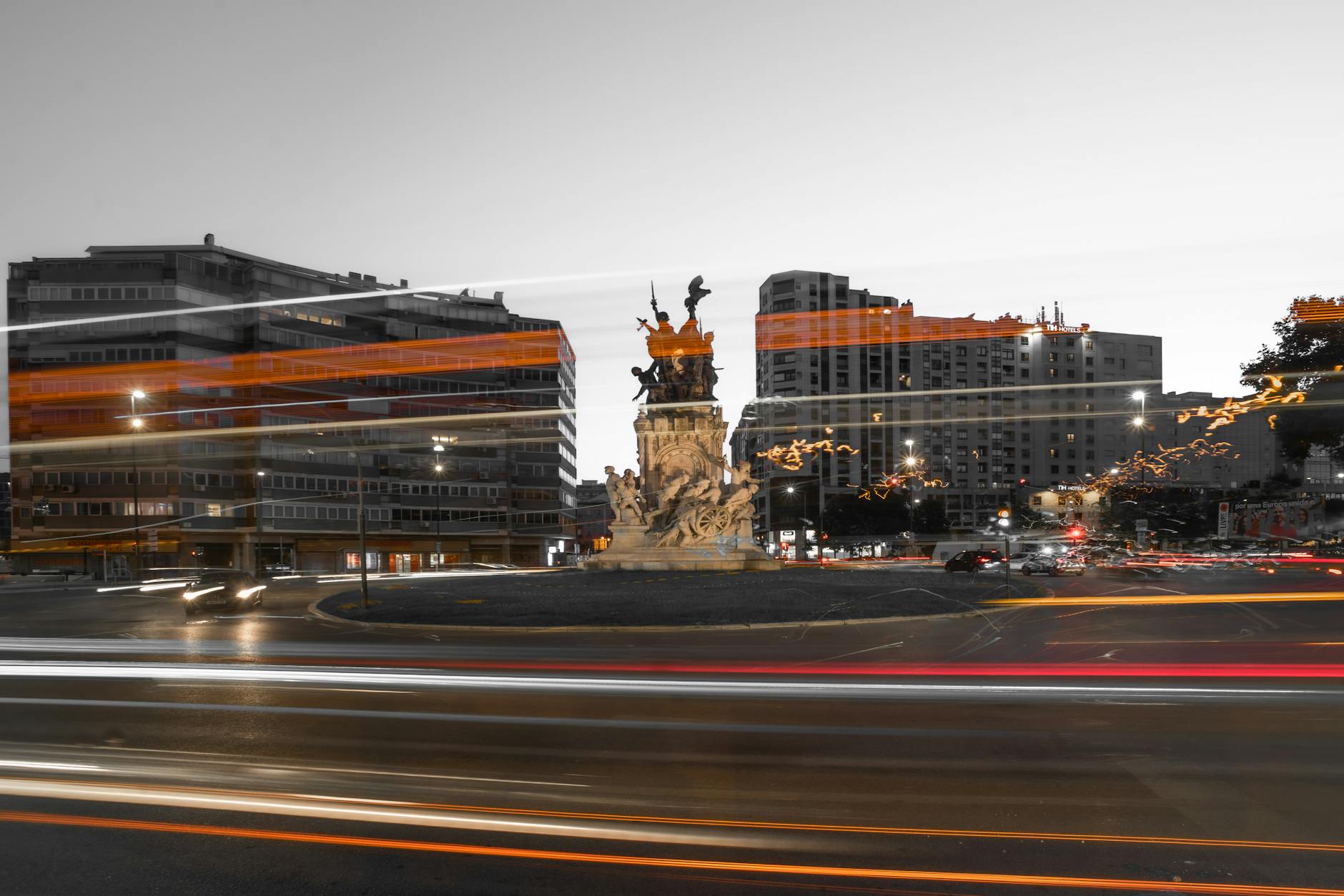 Long exposure of Entrecampos Square in Lisbon highlighting blurred lights and iconic statue.