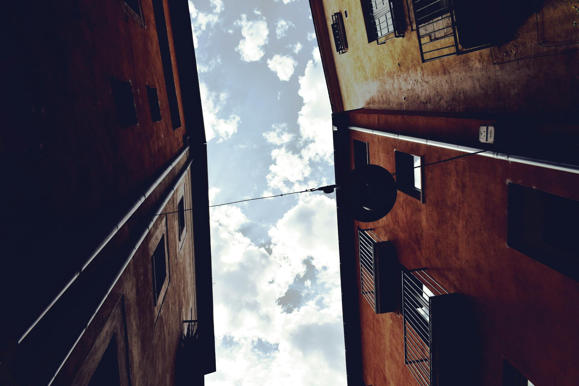 Low-angle view of an alley between buildings with a clear sky in Girona, Spain.