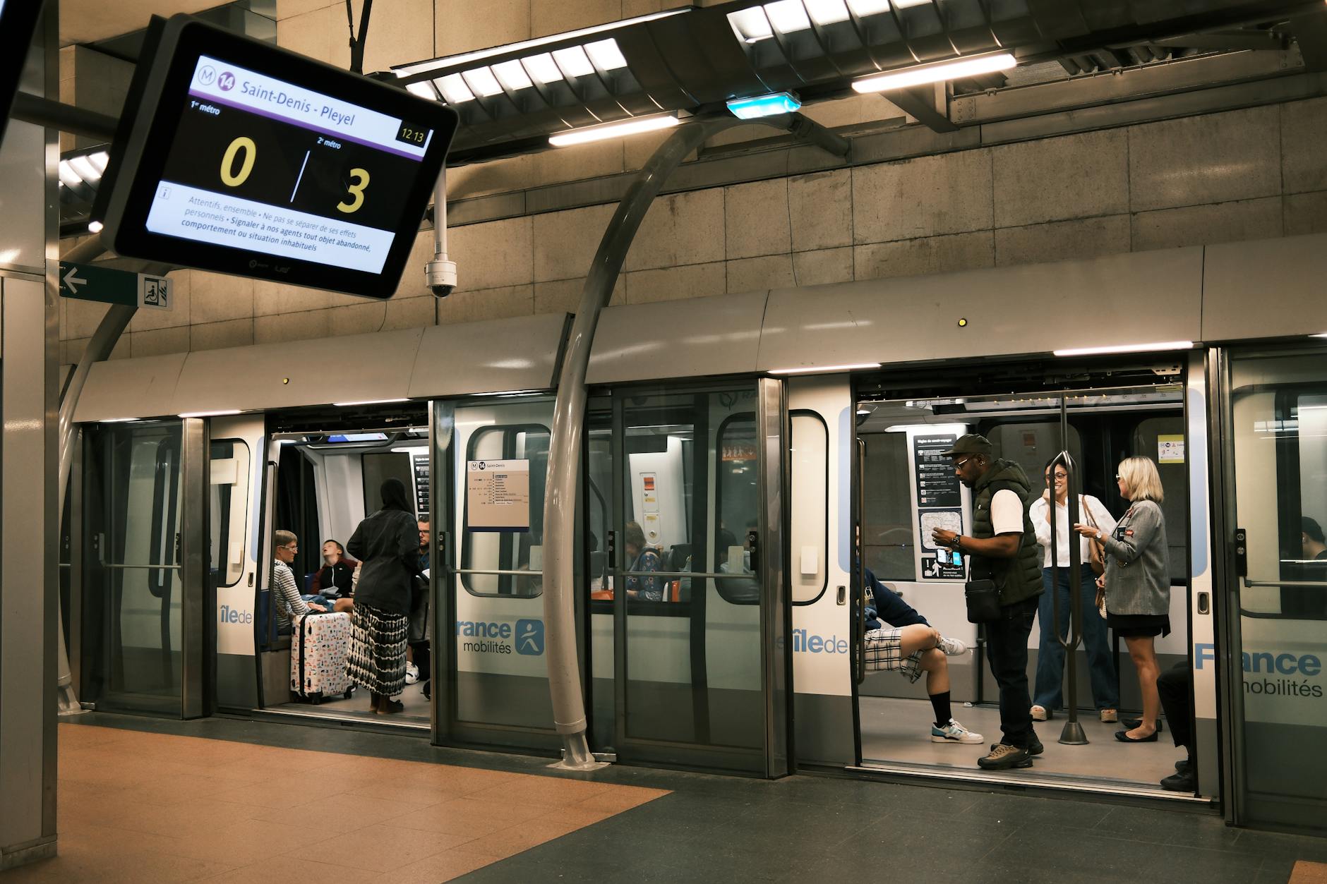 People waiting and boarding at Saint-Denis metro station in Paris.