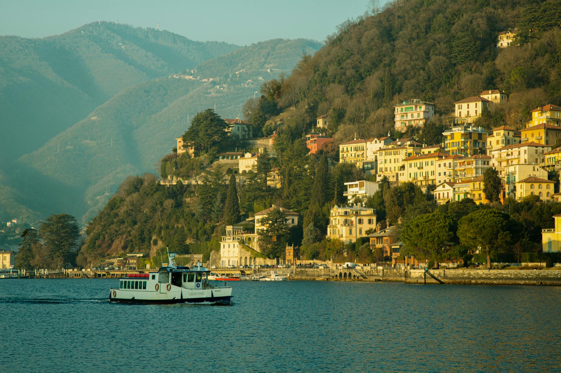 Como encontrar eventos grátis no Visit Lisboa em 2 minutos (com filtros certeiros) 6 Picturesque view of Lago di Como with colorful hillside houses and a ferry in spring.