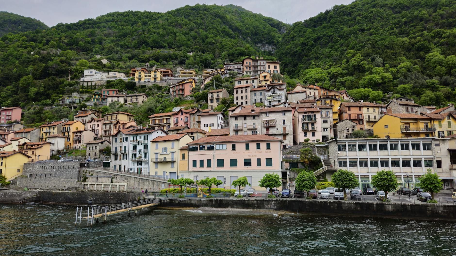 Picturesque village on Lake Como's shore with colorful hillside houses in Lombardy, Italy.