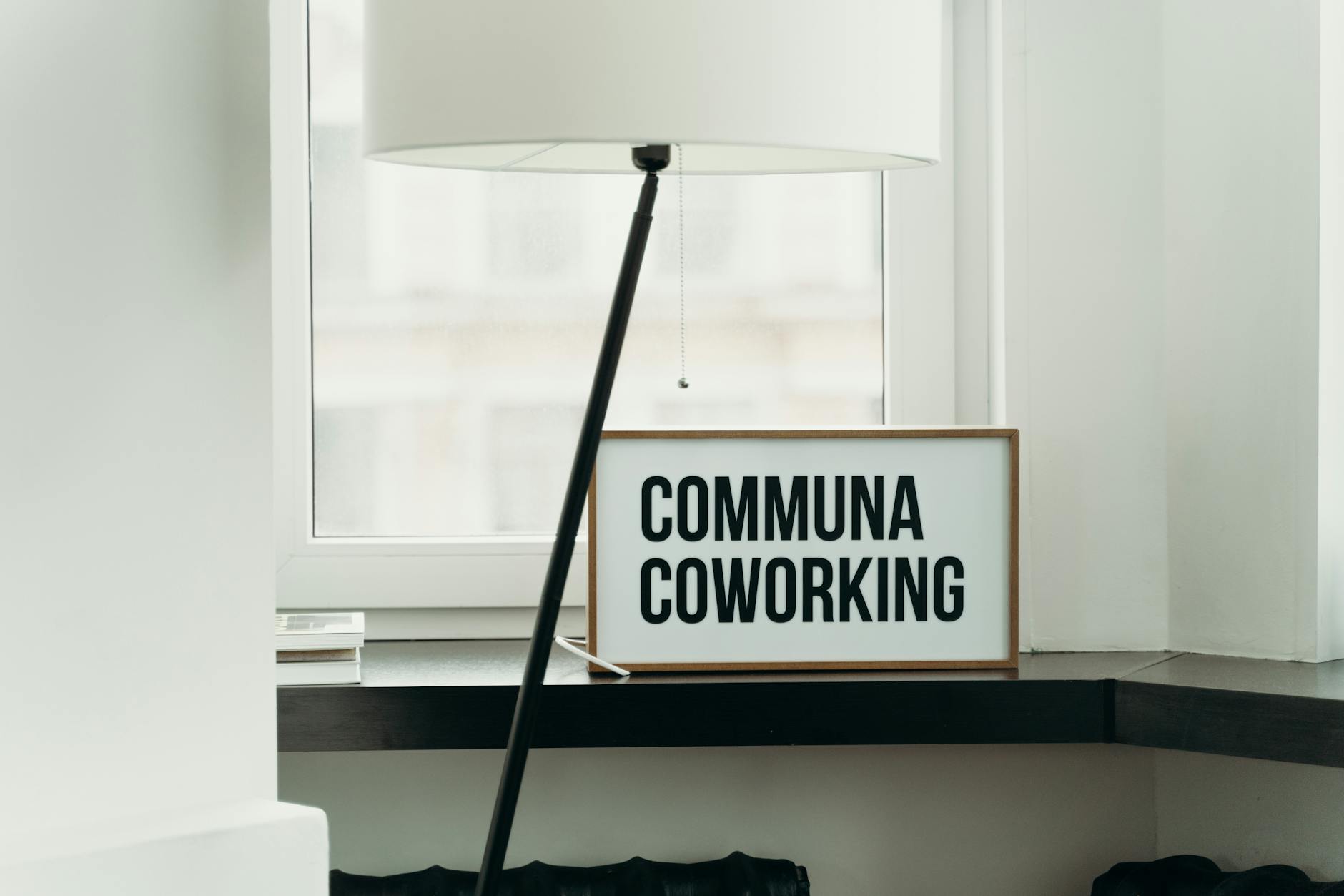 Simple and elegant coworking space decor with soft lamp lighting and window view.