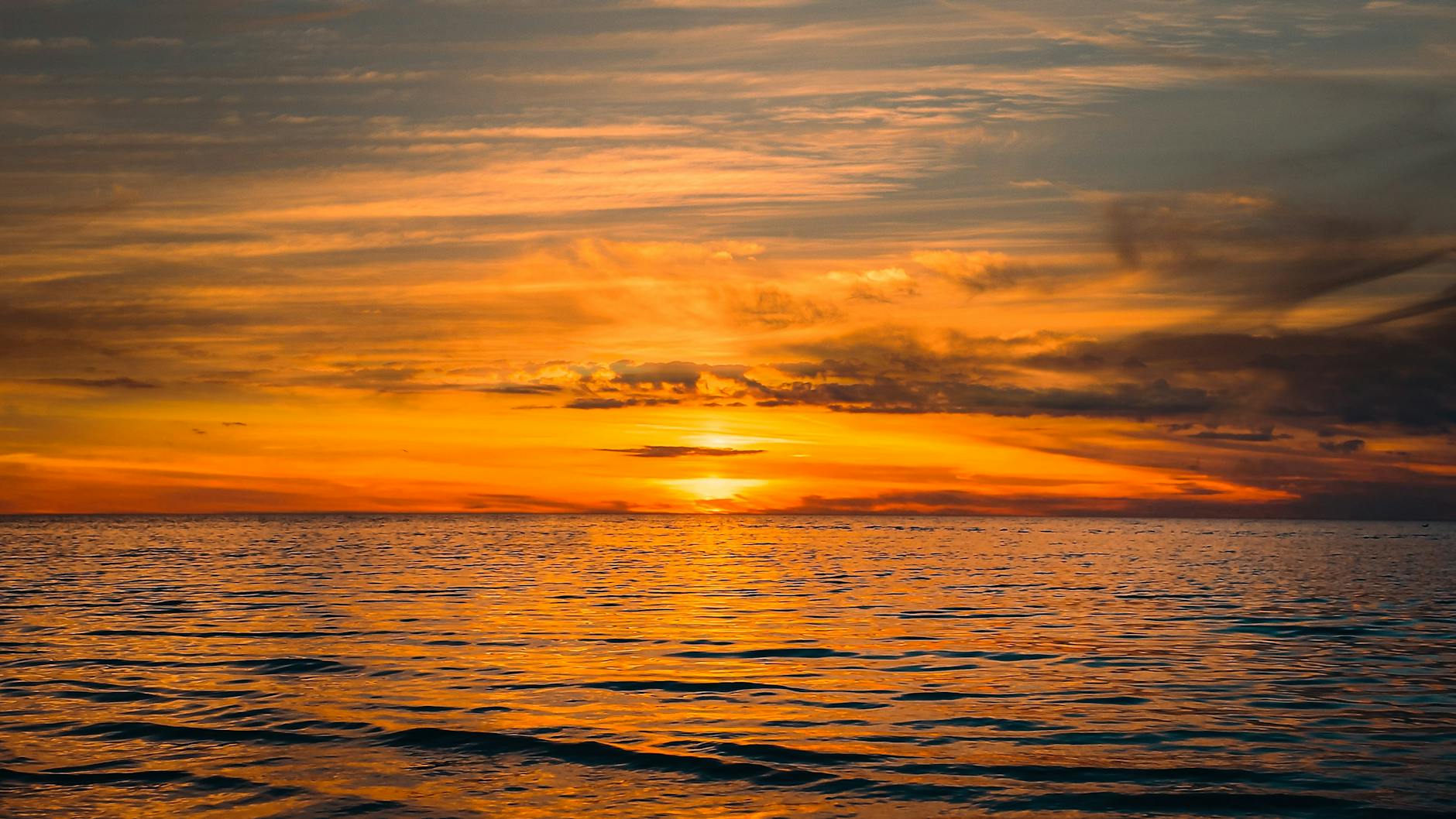 Stunning golden sunset over a calm ocean, capturing nature's serene beauty and vibrant horizons.