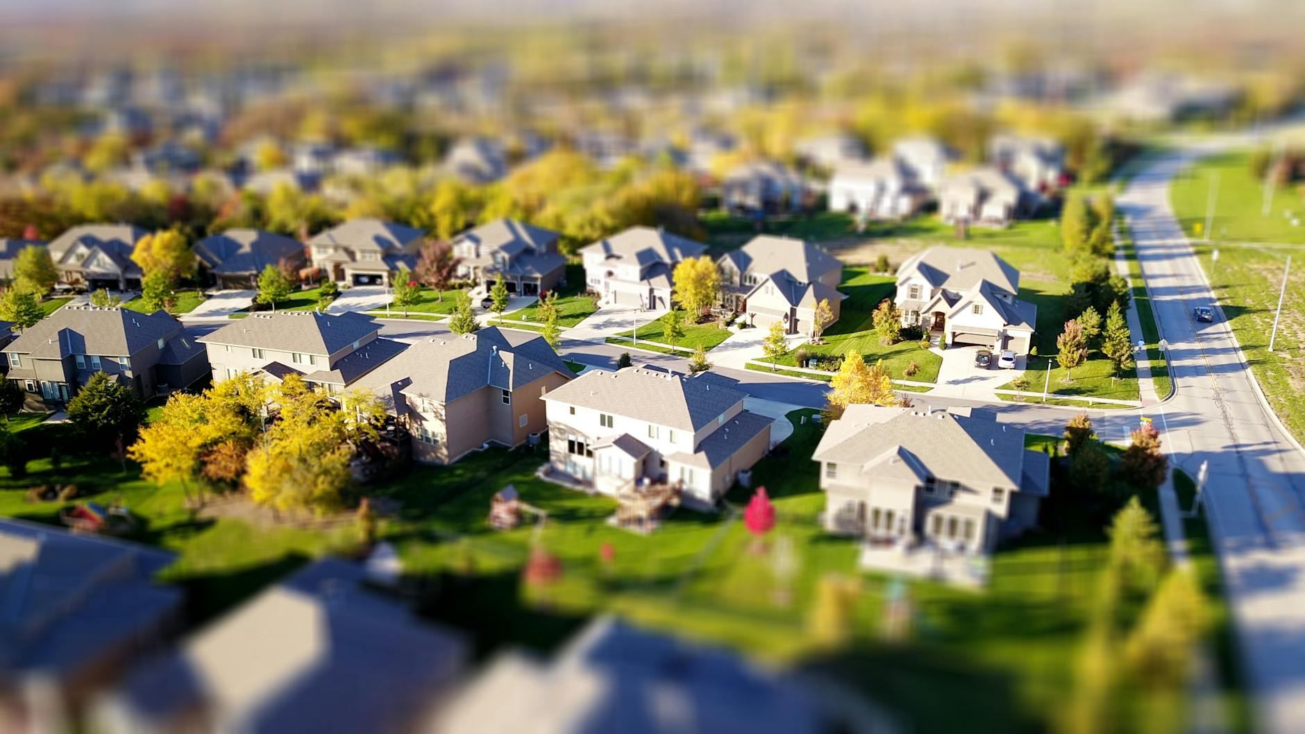 Telheiras: Cafés, Caminhadas E Um “Mood” De Bairro 4 Tilt-shift aerial photo of a suburban neighborhood with green lawns and roads.